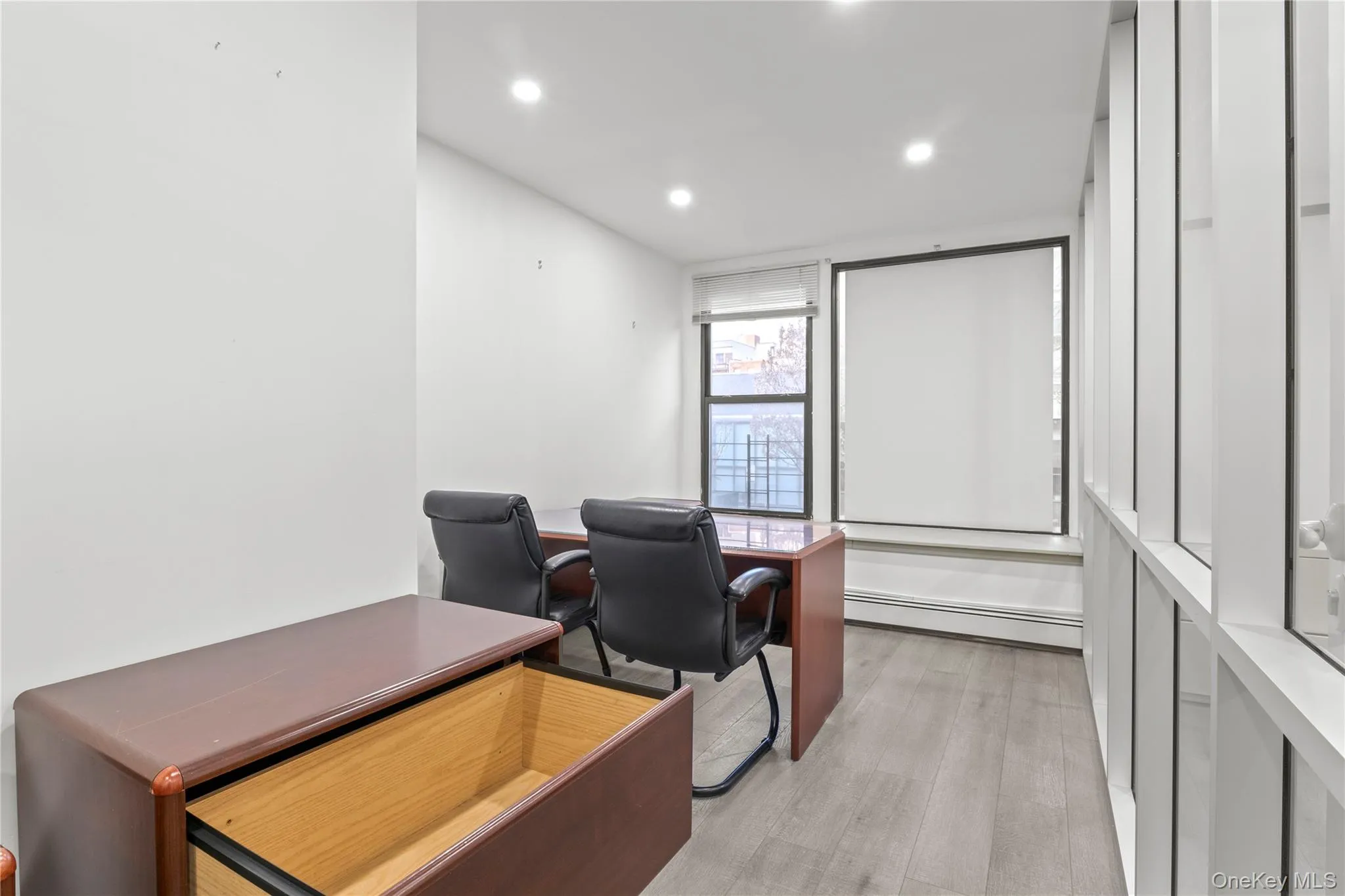 Office space with a baseboard heating unit, recessed lighting, and light wood-type flooring Office space with a baseboard heating unit, recessed lighting, and light wood-type flooring