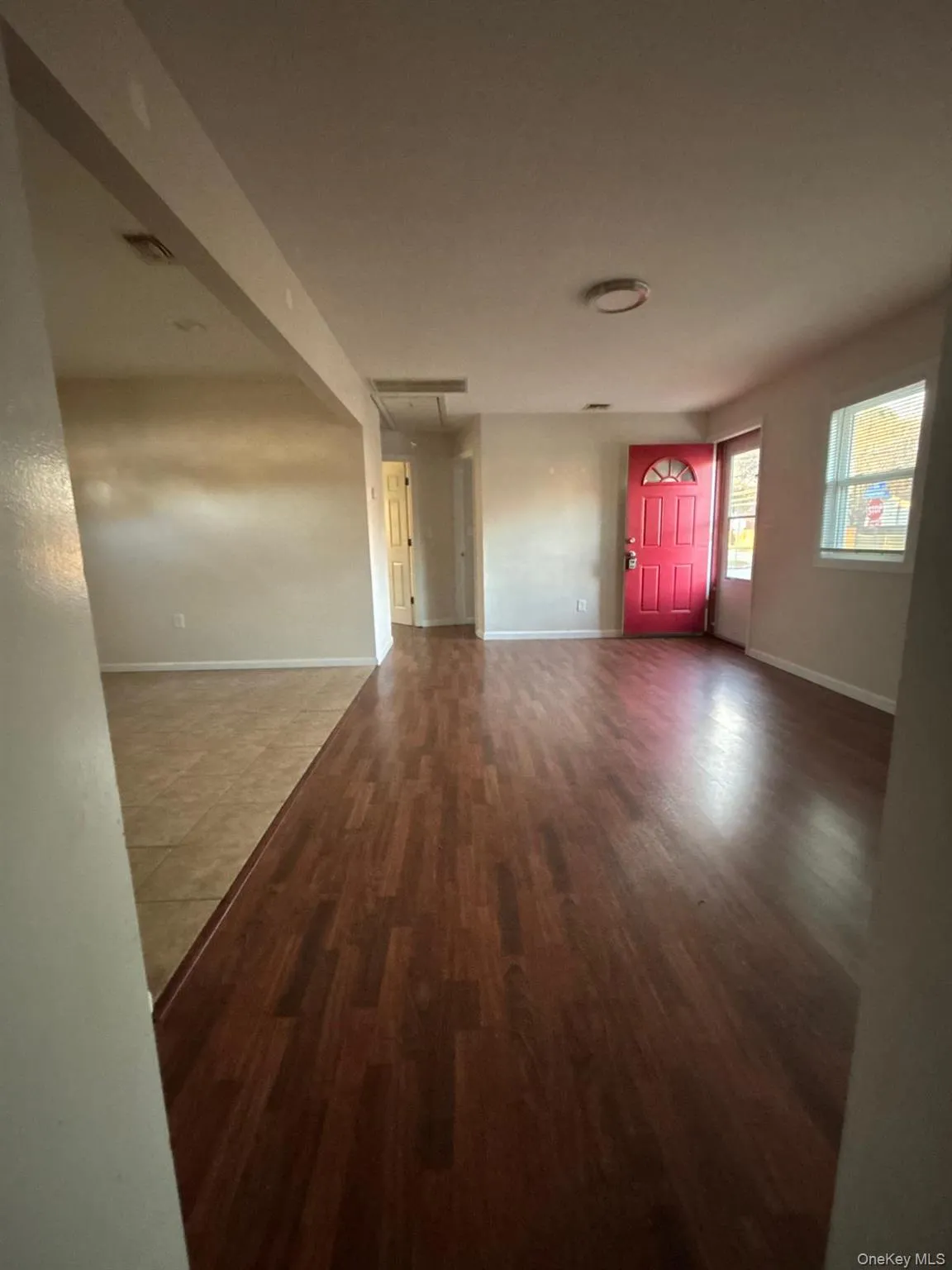 Unfurnished living room with attic access and wood finished floors Unfurnished living room with attic access and wood finished floors