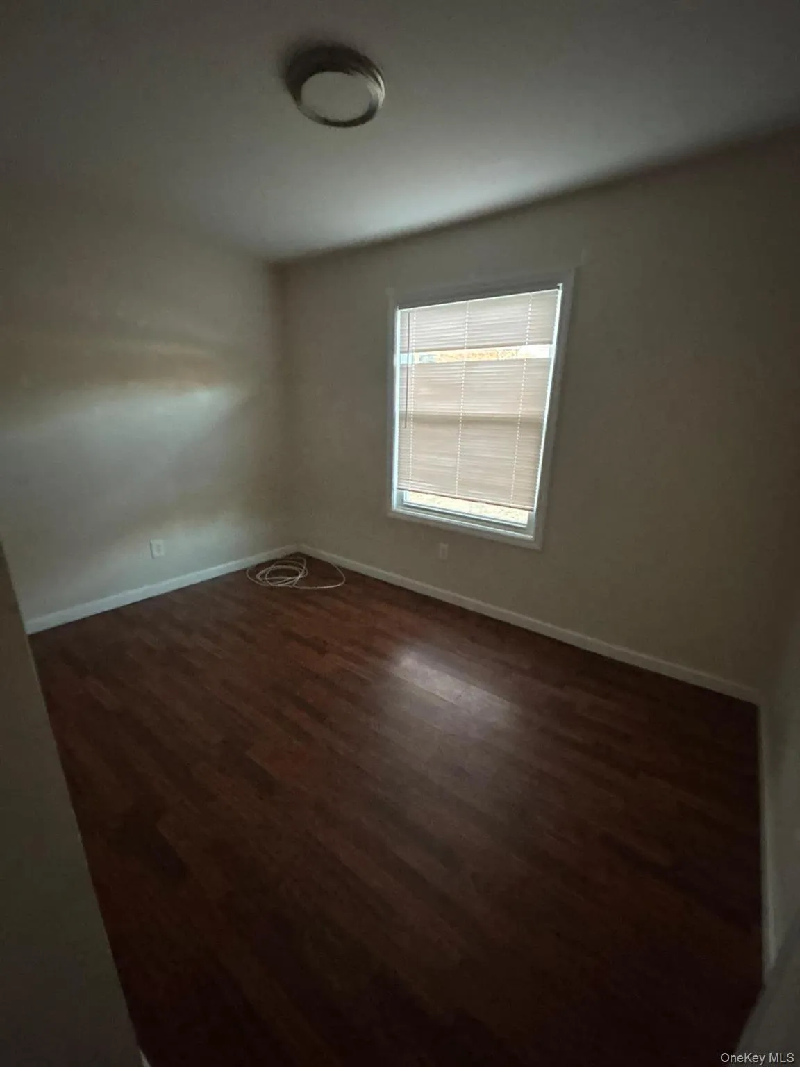 Unfurnished room featuring baseboards and dark wood finished floors Unfurnished room featuring baseboards and dark wood finished floors