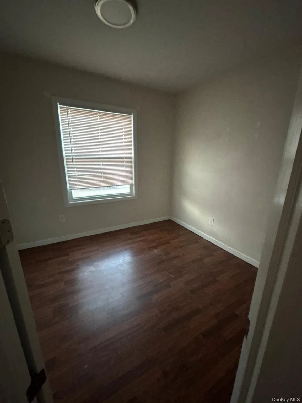 Empty room with baseboards and dark wood finished floors Empty room with baseboards and dark wood finished floors