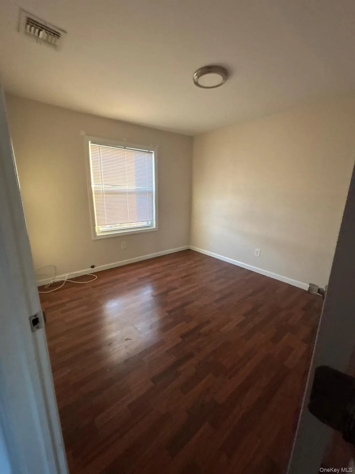 Unfurnished room featuring dark wood-style flooring and baseboards Unfurnished room featuring dark wood-style flooring and baseboards