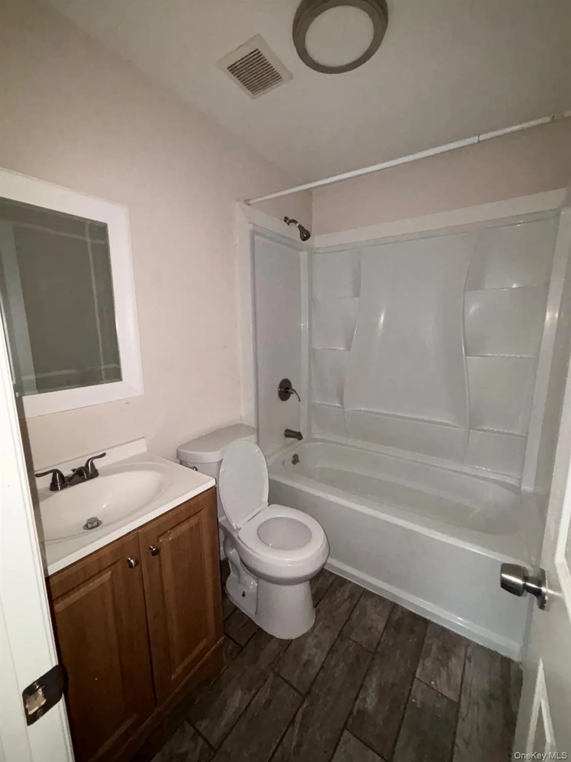 Bathroom featuring shower / bathtub combination, vanity, and wood tiled floors Bathroom featuring shower / bathtub combination, vanity, and wood tiled floors
