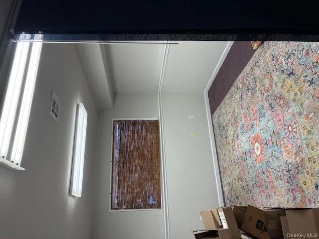 Unfurnished room featuring baseboards and dark carpet Unfurnished room featuring baseboards and dark carpet