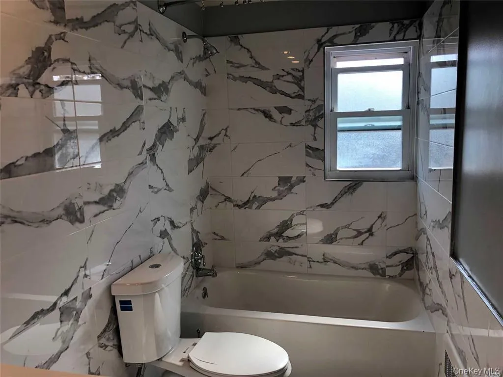 Full bathroom with toilet and washtub / shower combination Full bathroom with toilet and washtub / shower combination