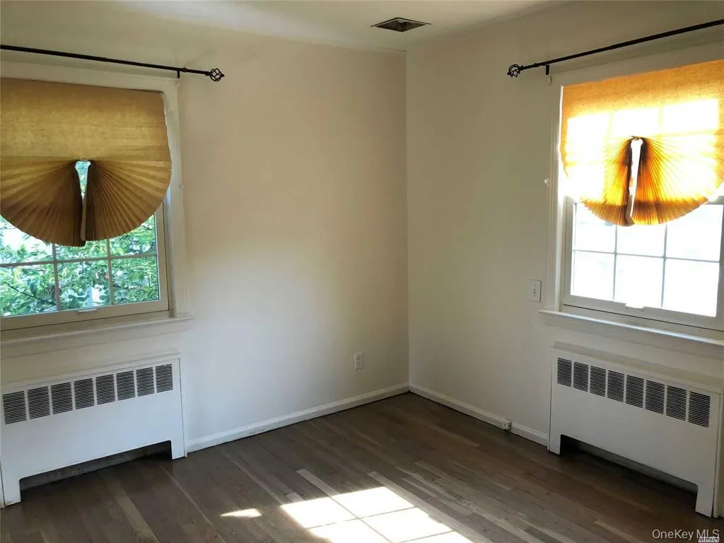 Spare room with radiator heating unit and dark wood-type flooring Spare room with radiator heating unit and dark wood-type flooring