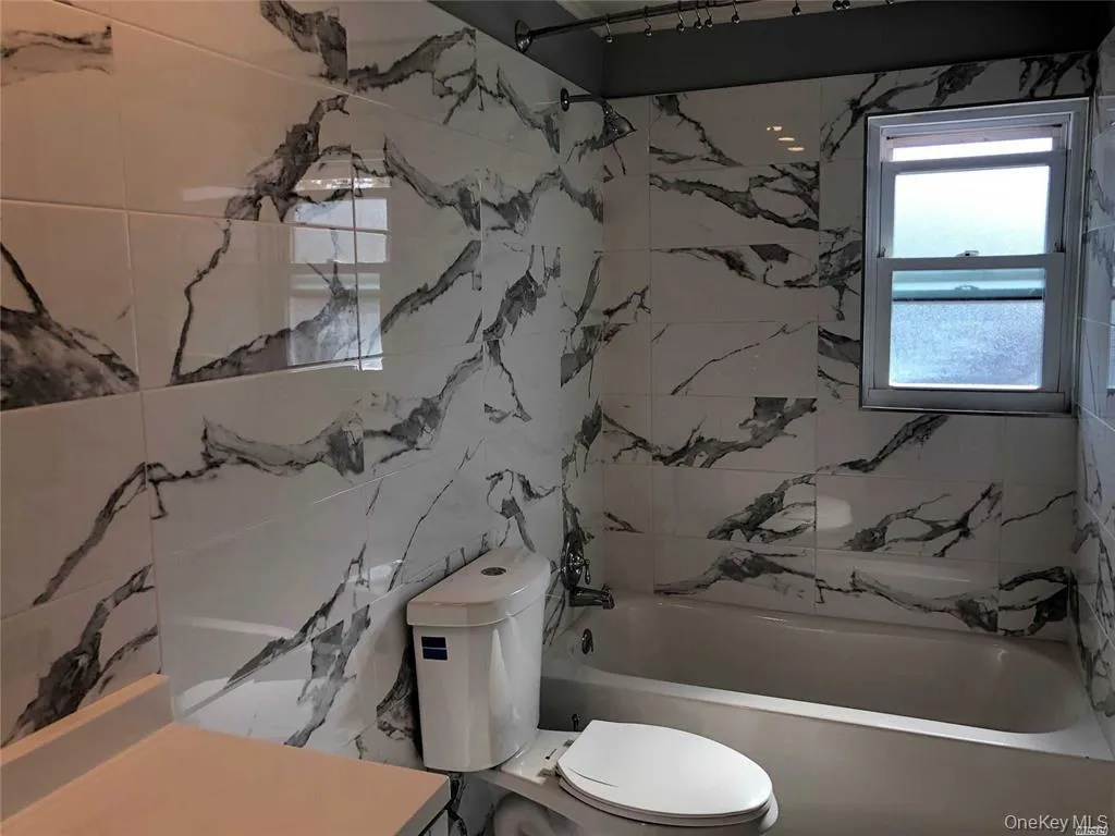 Bathroom featuring toilet and tub / shower combination Bathroom featuring toilet and tub / shower combination