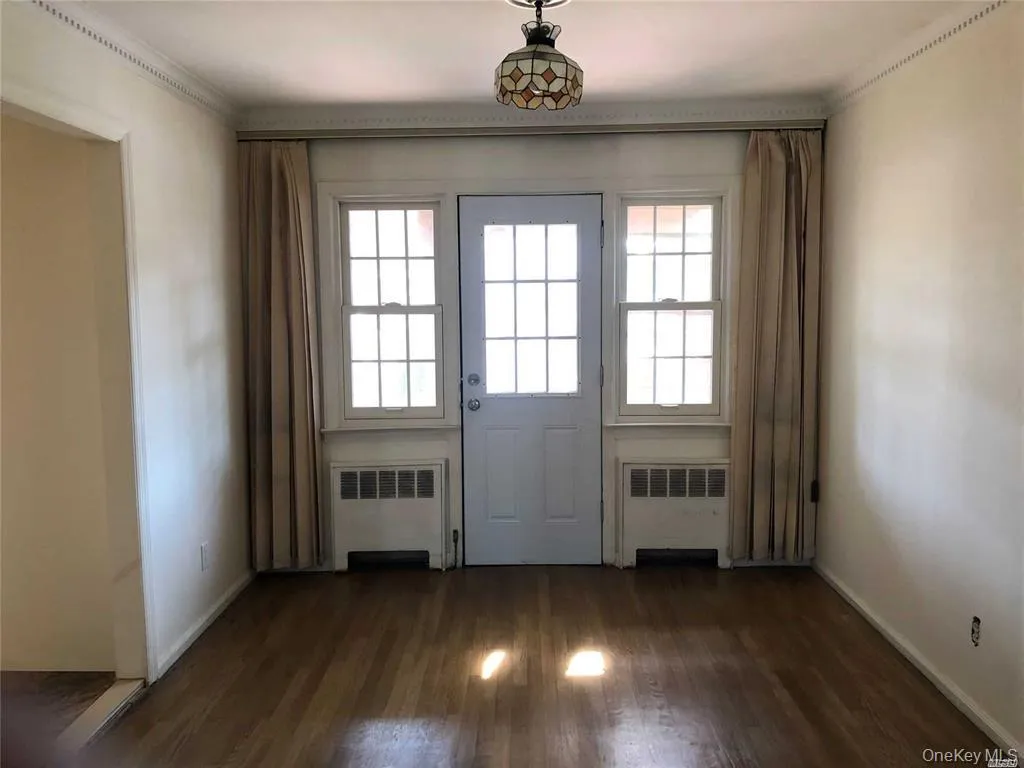 Entryway featuring radiator heating unit, wood finished floors, and plenty of natural light Entryway featuring radiator heating unit, wood finished floors, and plenty of natural light