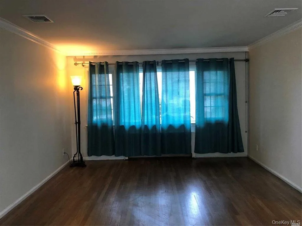 Unfurnished room with crown molding and dark wood finished floors Unfurnished room with crown molding and dark wood finished floors