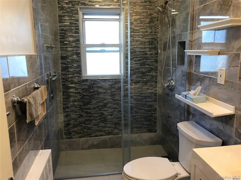 Full bath with vanity, a stall shower, and healthy amount of natural light Full bath with vanity, a stall shower, and healthy amount of natural light