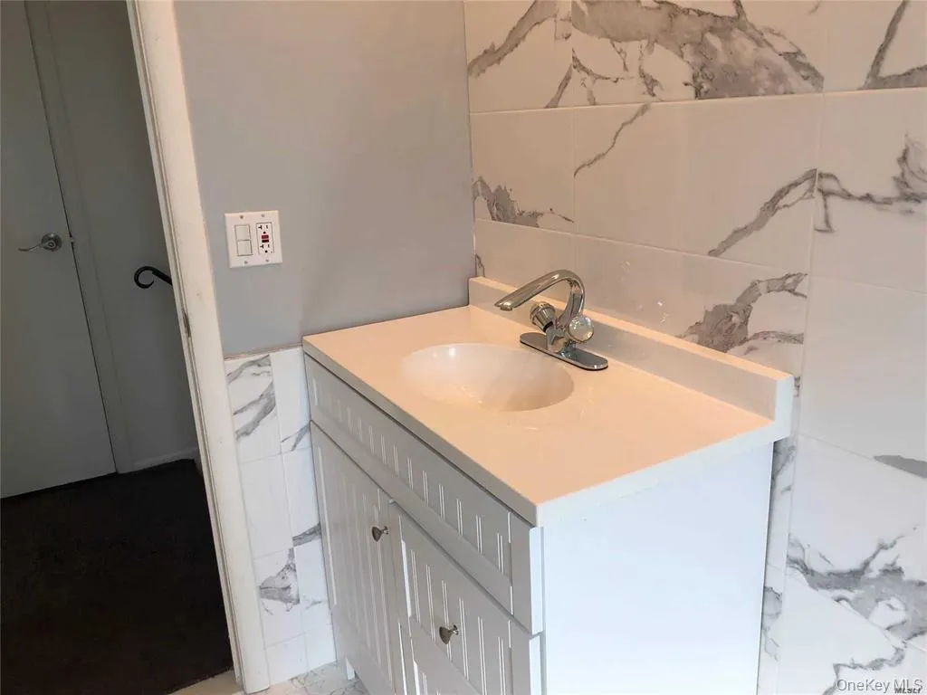 Bathroom featuring vanity and tile walls Bathroom featuring vanity and tile walls