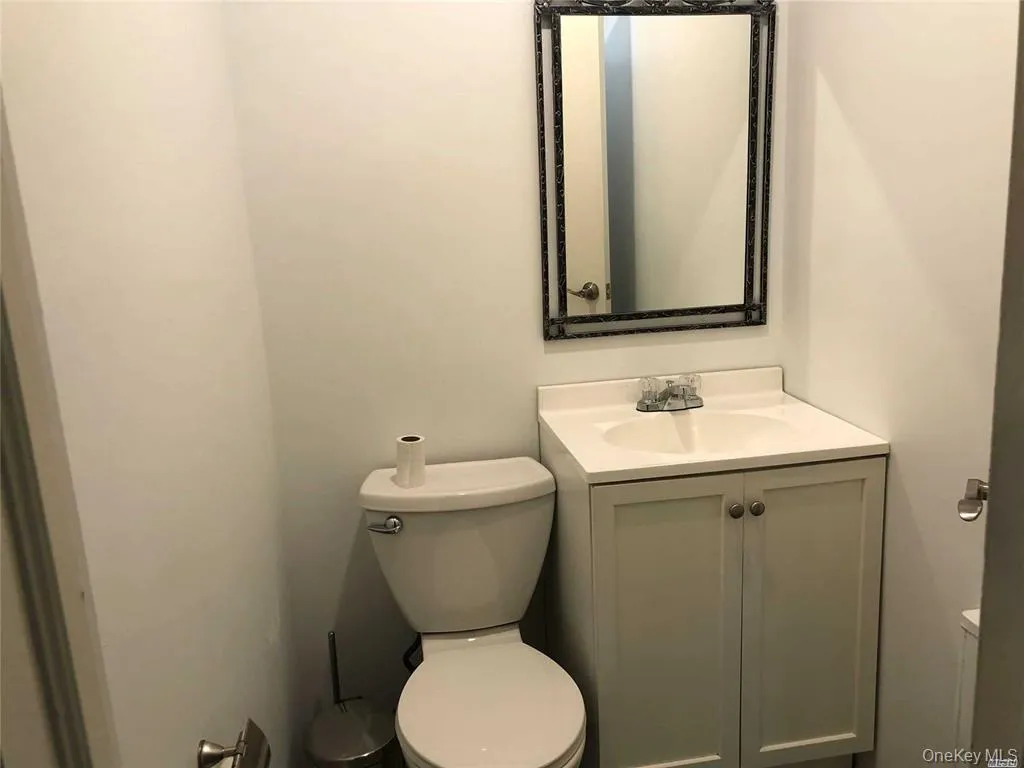 Half bath featuring toilet and vanity Half bath featuring toilet and vanity