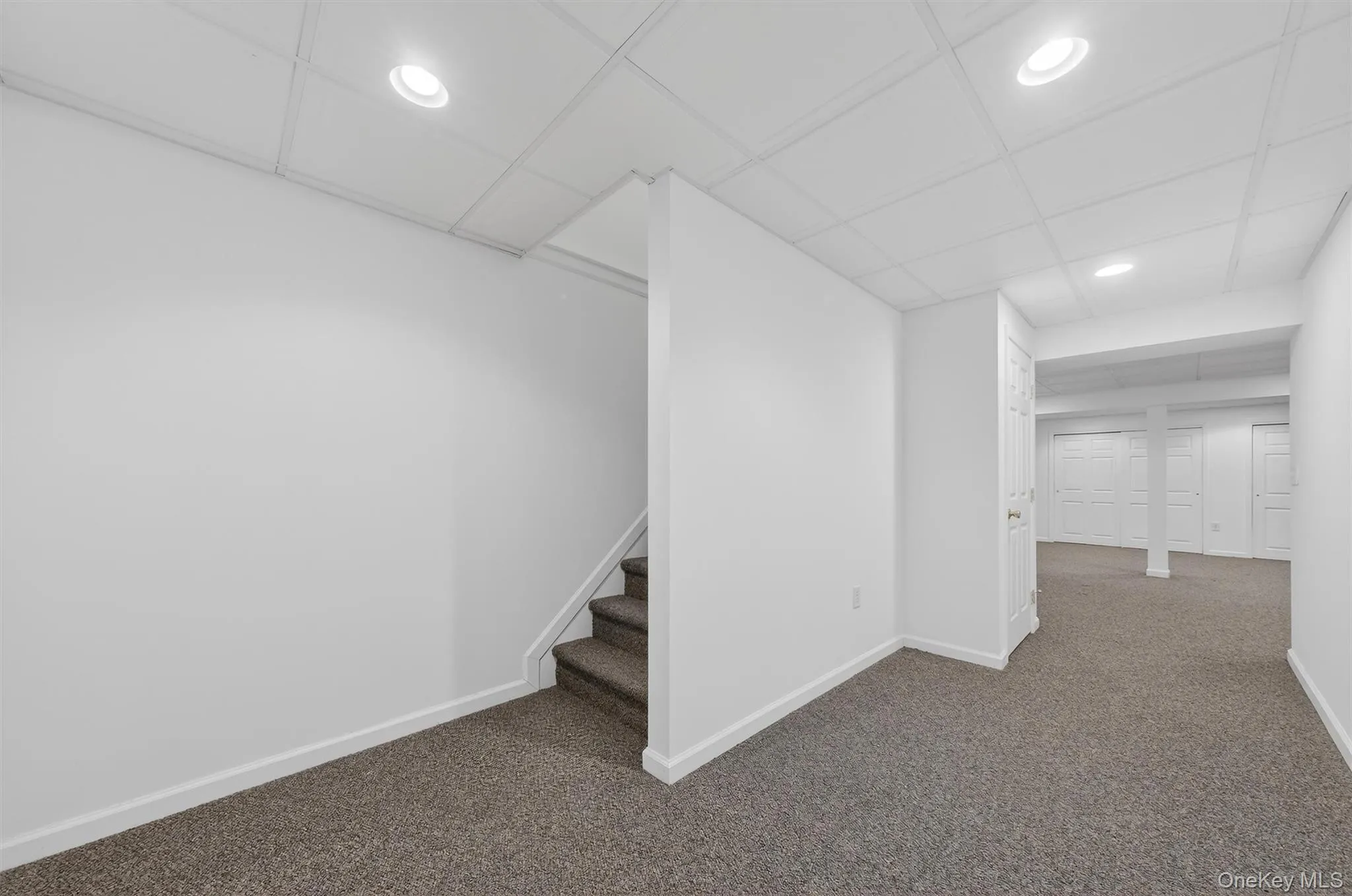 Finished below grade area featuring recessed lighting, carpet floors, and stairs Finished below grade area featuring recessed lighting, carpet floors, and stairs