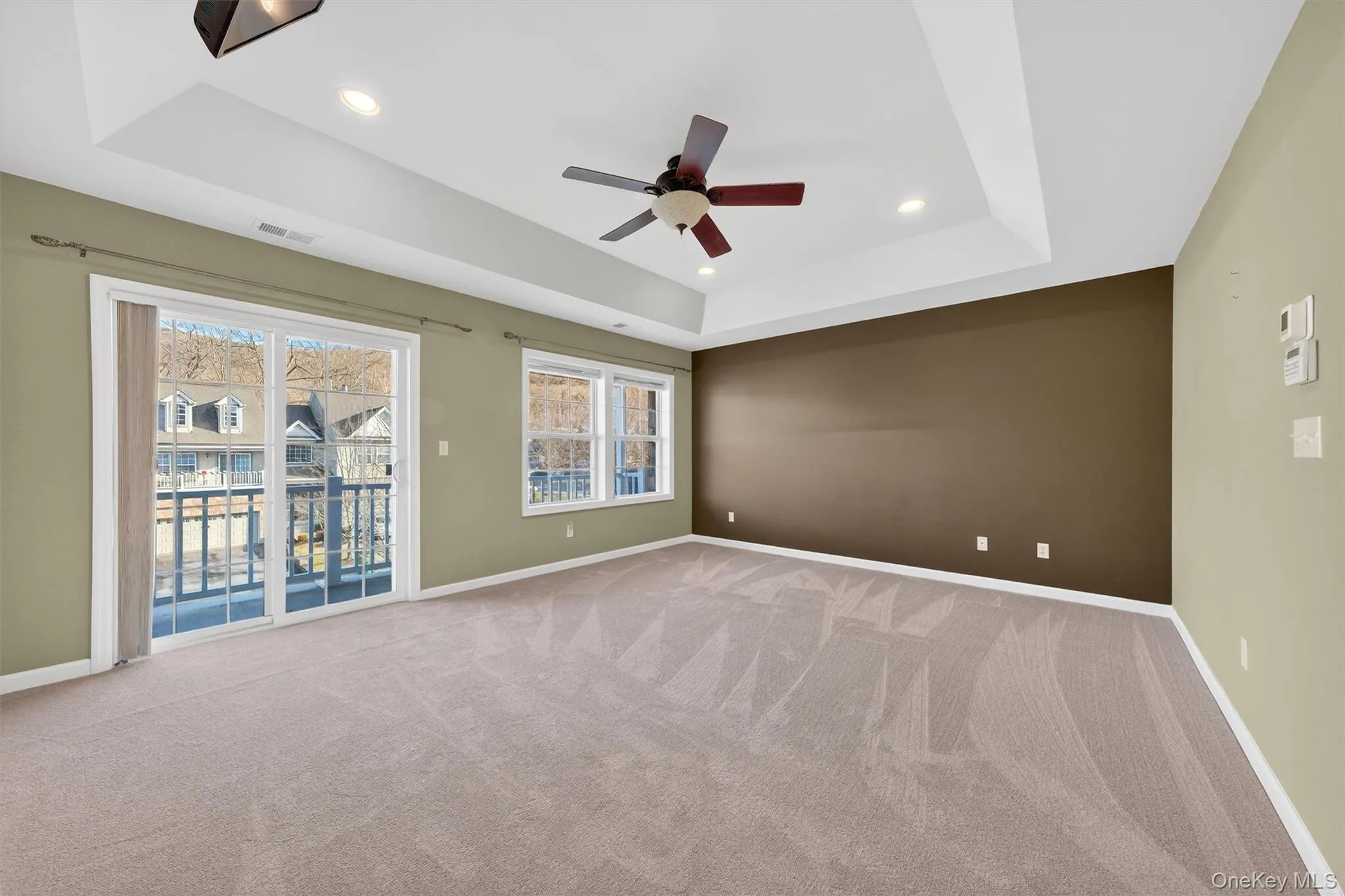 Spare room with a raised ceiling, recessed lighting, light carpet, and a ceiling fan Spare room with a raised ceiling, recessed lighting, light carpet, and a ceiling fan