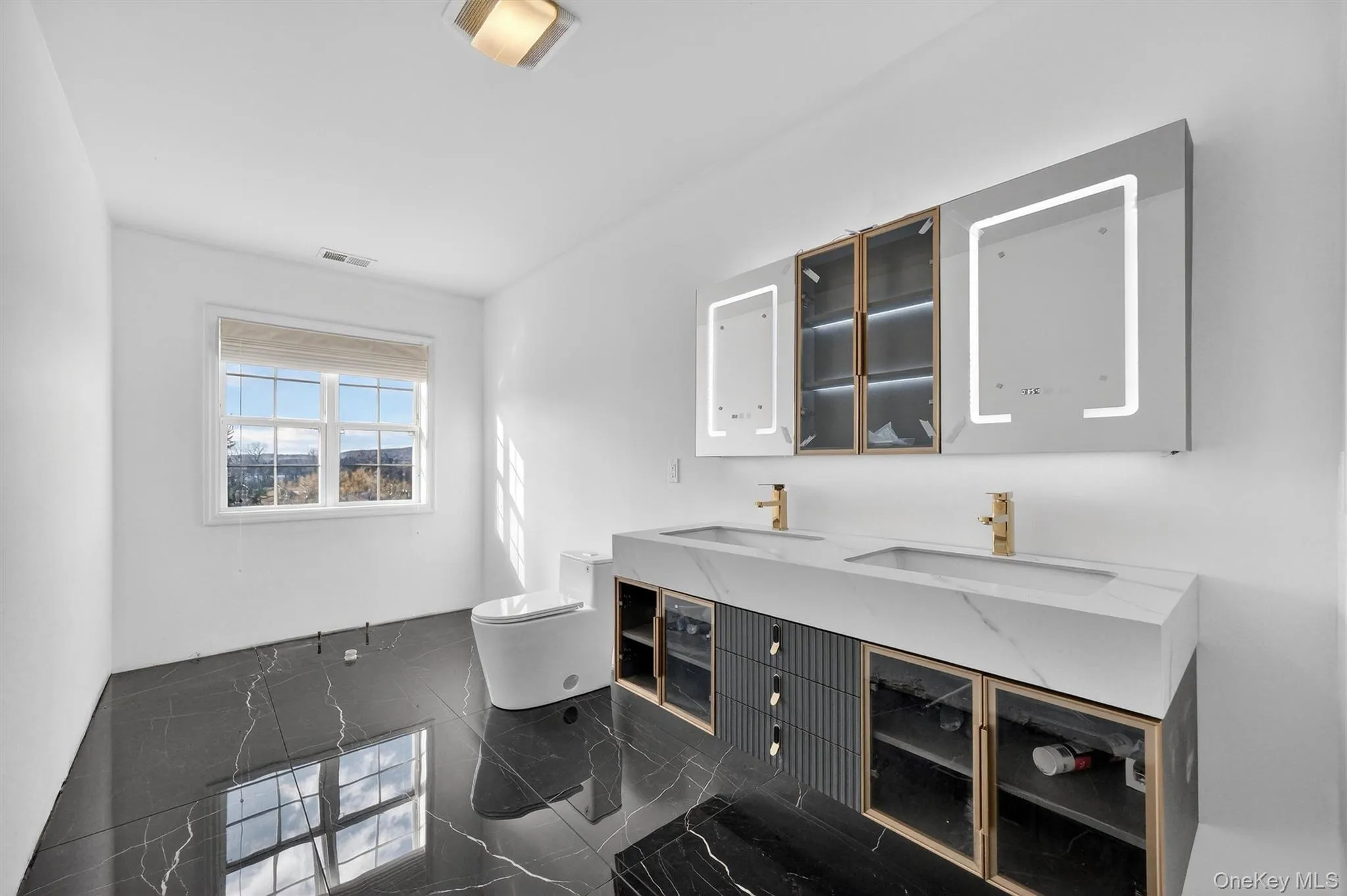 Full bathroom featuring double vanity and toilet Full bathroom featuring double vanity and toilet