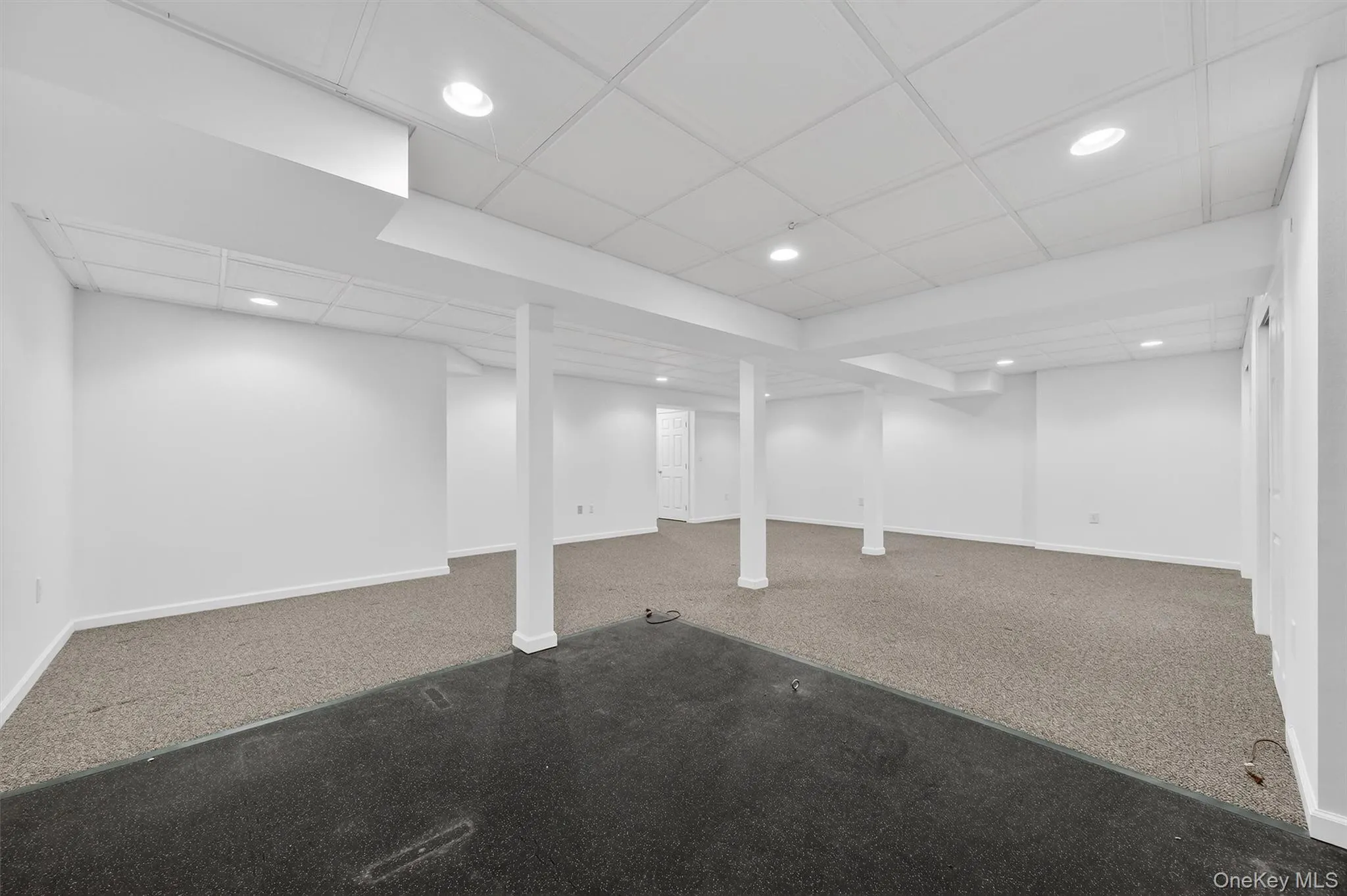 Finished basement with carpet flooring and a paneled ceiling Finished basement with carpet flooring and a paneled ceiling