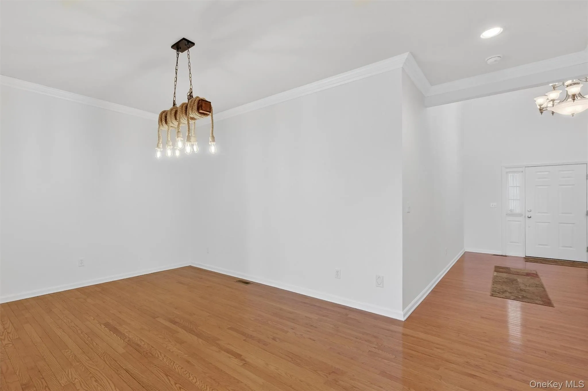Unfurnished dining area with a chandelier, wood finished floors, and ornamental molding Unfurnished dining area with a chandelier, wood finished floors, and ornamental molding