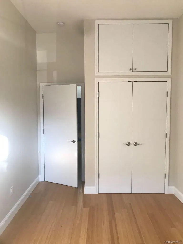 Unfurnished bedroom with light wood finished floors and a closet Unfurnished bedroom with light wood finished floors and a closet