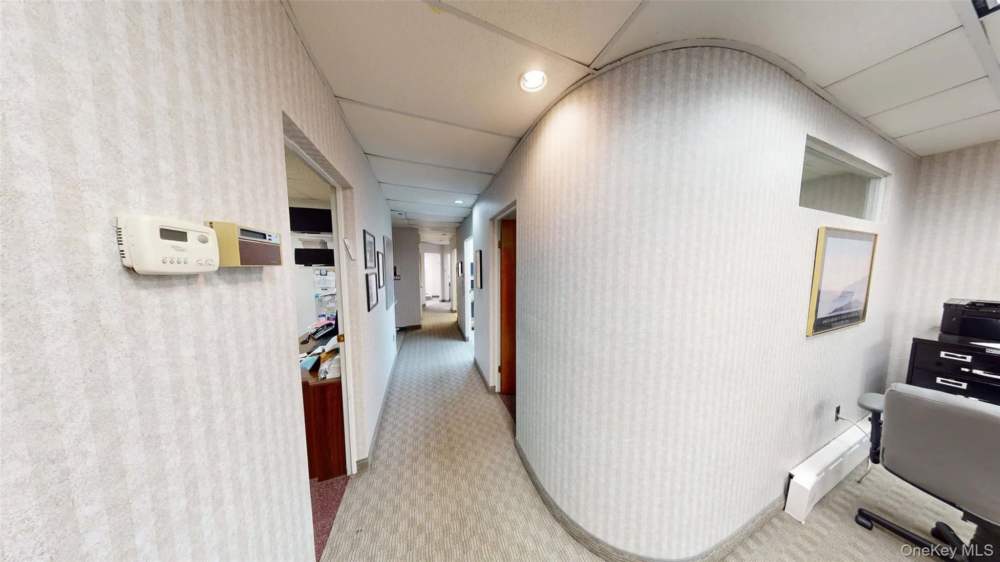 Hall with light recessed lighting, wallpapered walls, and a desk Hall with light recessed lighting, wallpapered walls, and a desk