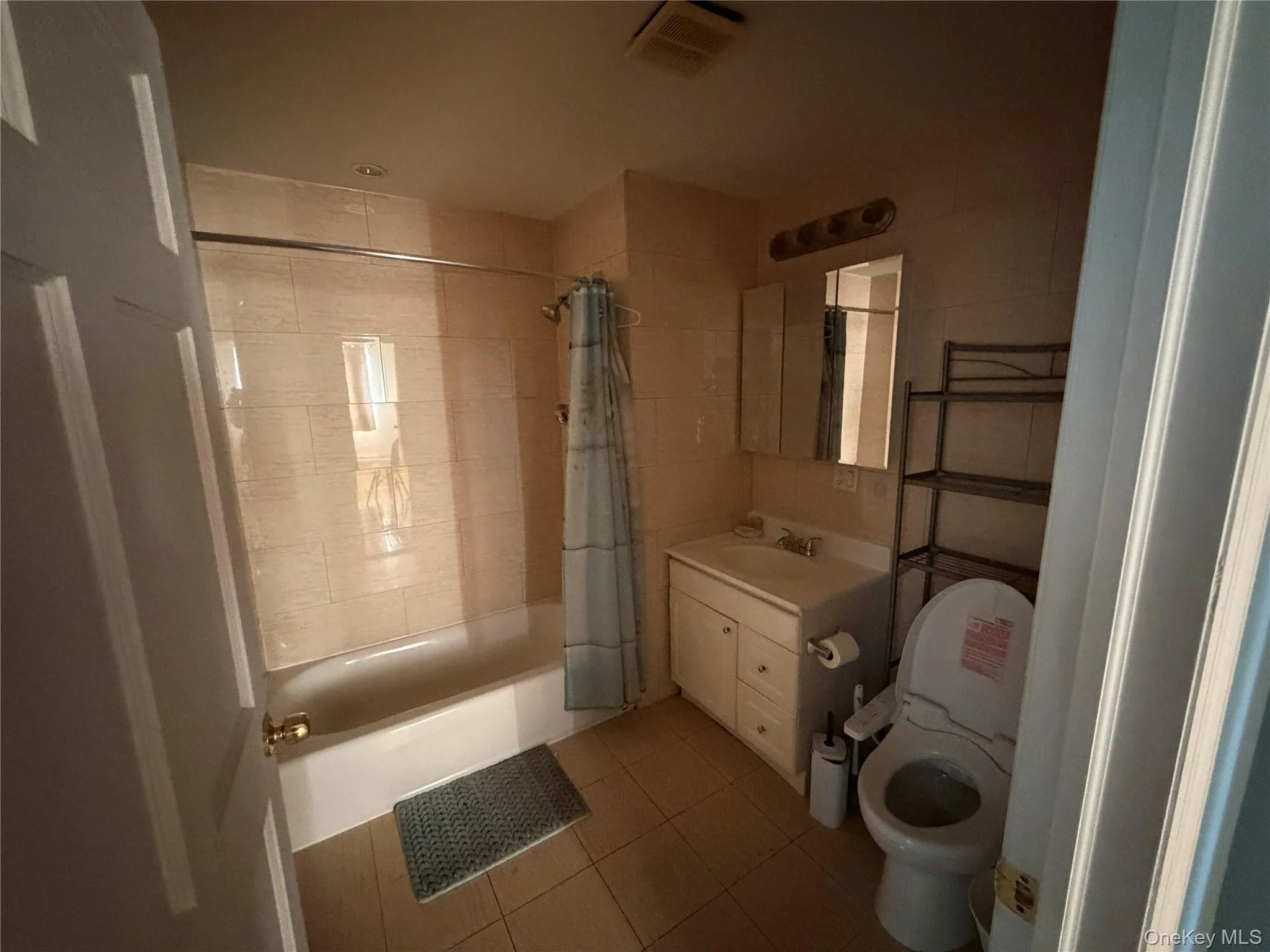 Full bathroom featuring vanity, shower / bathtub combination with curtain, and tile patterned flooring Full bathroom featuring vanity, shower / bathtub combination with curtain, and tile patterned flooring