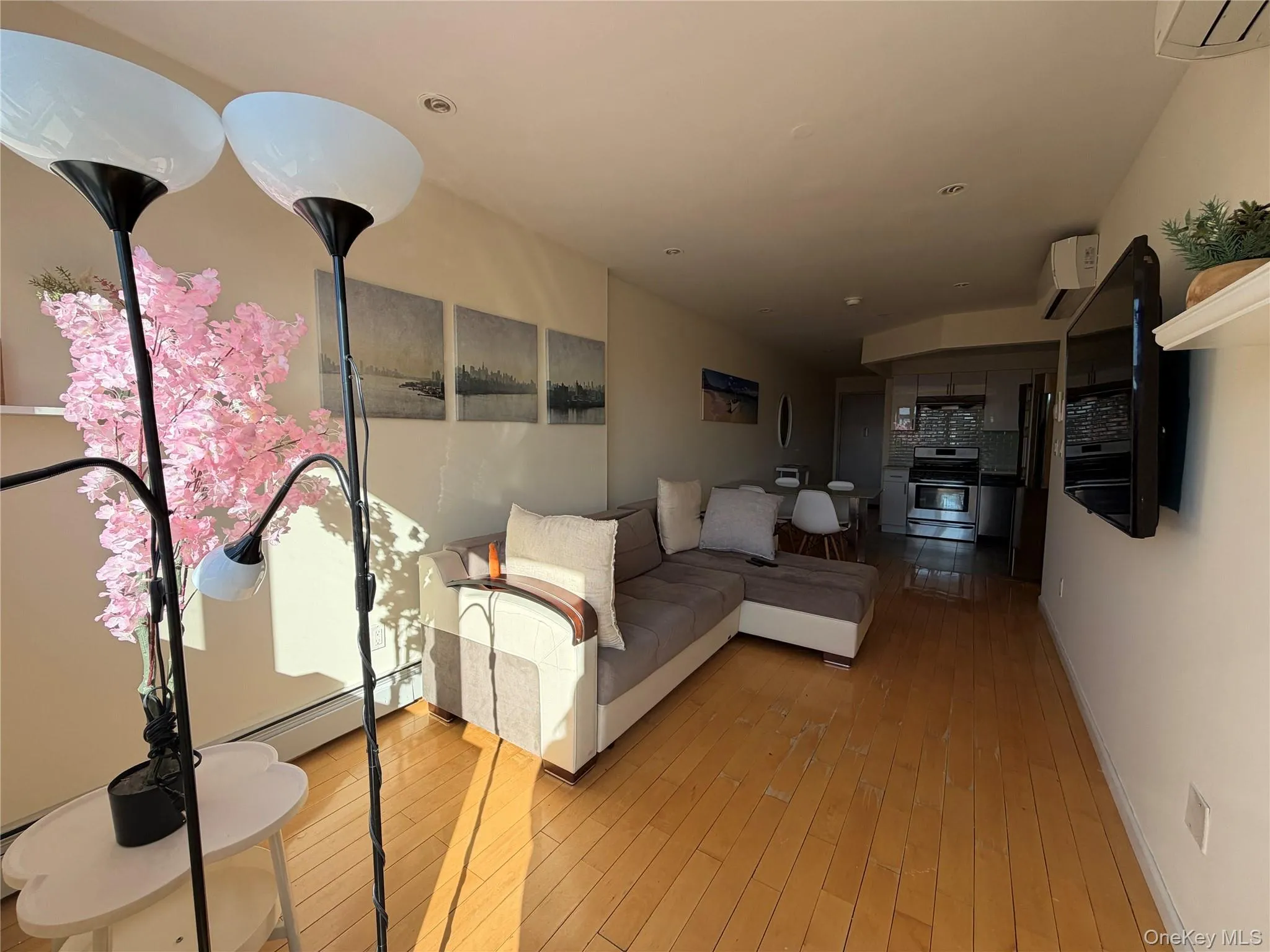 Living area with light wood-style floors and baseboard heating Living area with light wood-style floors and baseboard heating