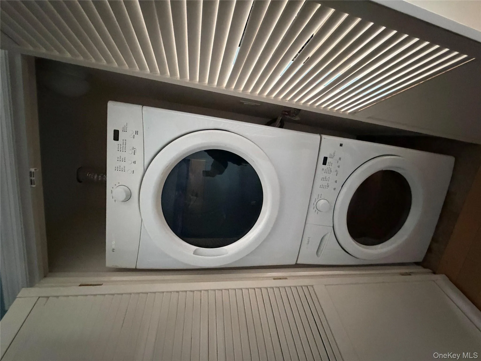 Laundry room with stacked washing machine and dryer Laundry room with stacked washing machine and dryer