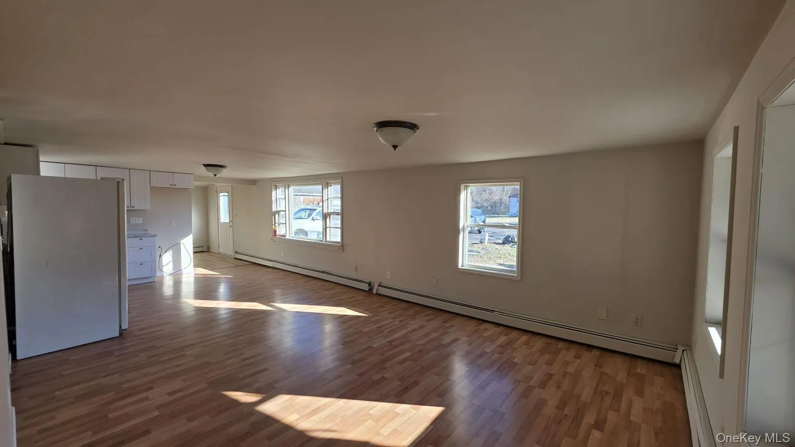 Spare room featuring dark wood finished floors and baseboard heating Spare room featuring dark wood finished floors and baseboard heating