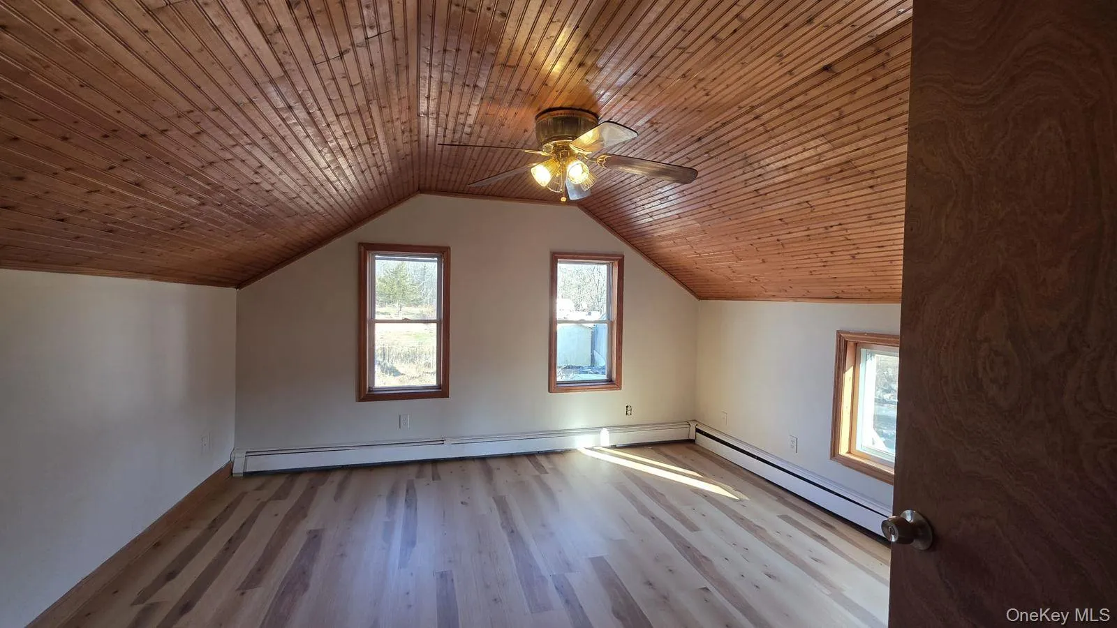 Additional living space with wooden ceiling, healthy amount of natural light, light wood-style floors, ceiling fan, and baseboard heating Additional living space with wooden ceiling, healthy amount of natural light, light wood-style floors, ceiling fan, and baseboard heating