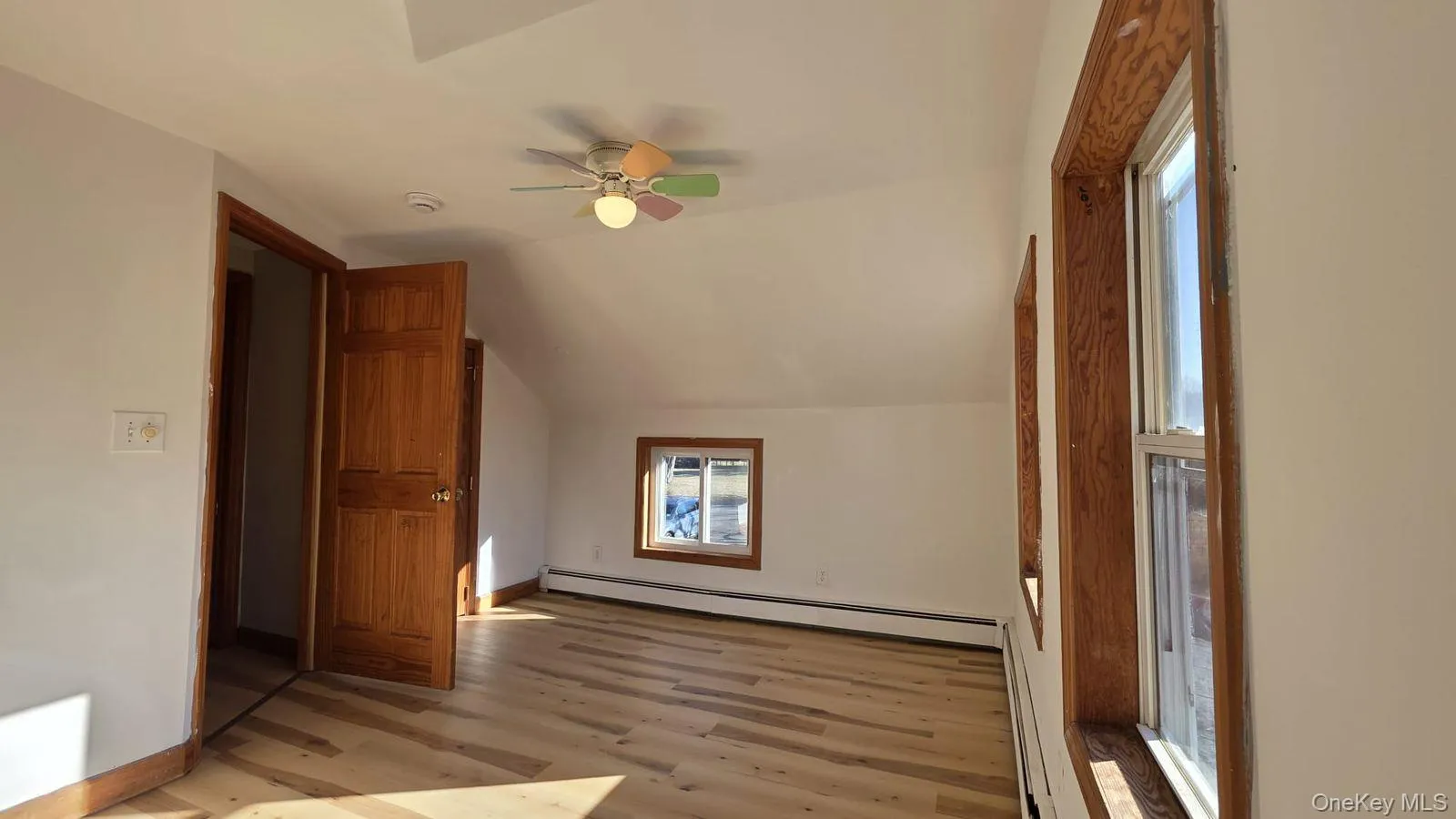 Bonus room with vaulted ceiling, a baseboard heating unit, light wood-type flooring, and a ceiling fan Bonus room with vaulted ceiling, a baseboard heating unit, light wood-type flooring, and a ceiling fan