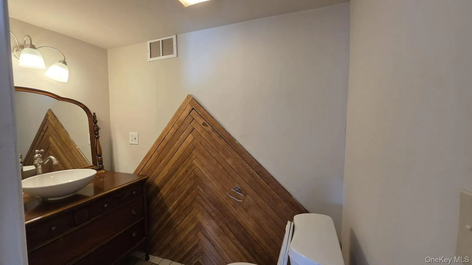 Half bathroom featuring vanity and toilet Half bathroom featuring vanity and toilet