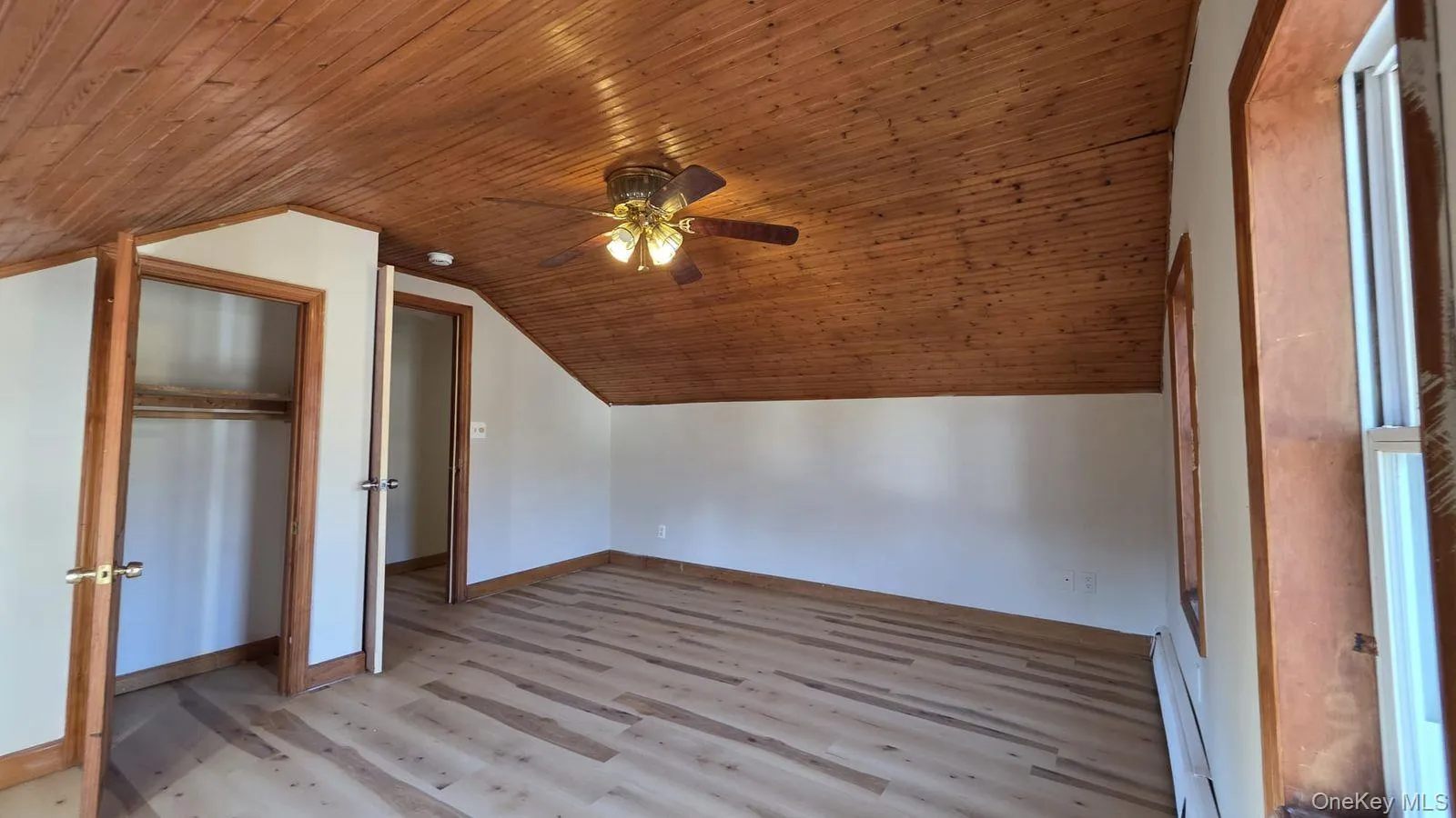 Additional living space featuring a baseboard heating unit, wood ceiling, lofted ceiling, light wood-type flooring, and a ceiling fan Additional living space featuring a baseboard heating unit, wood ceiling, lofted ceiling, light wood-type flooring, and a ceiling fan