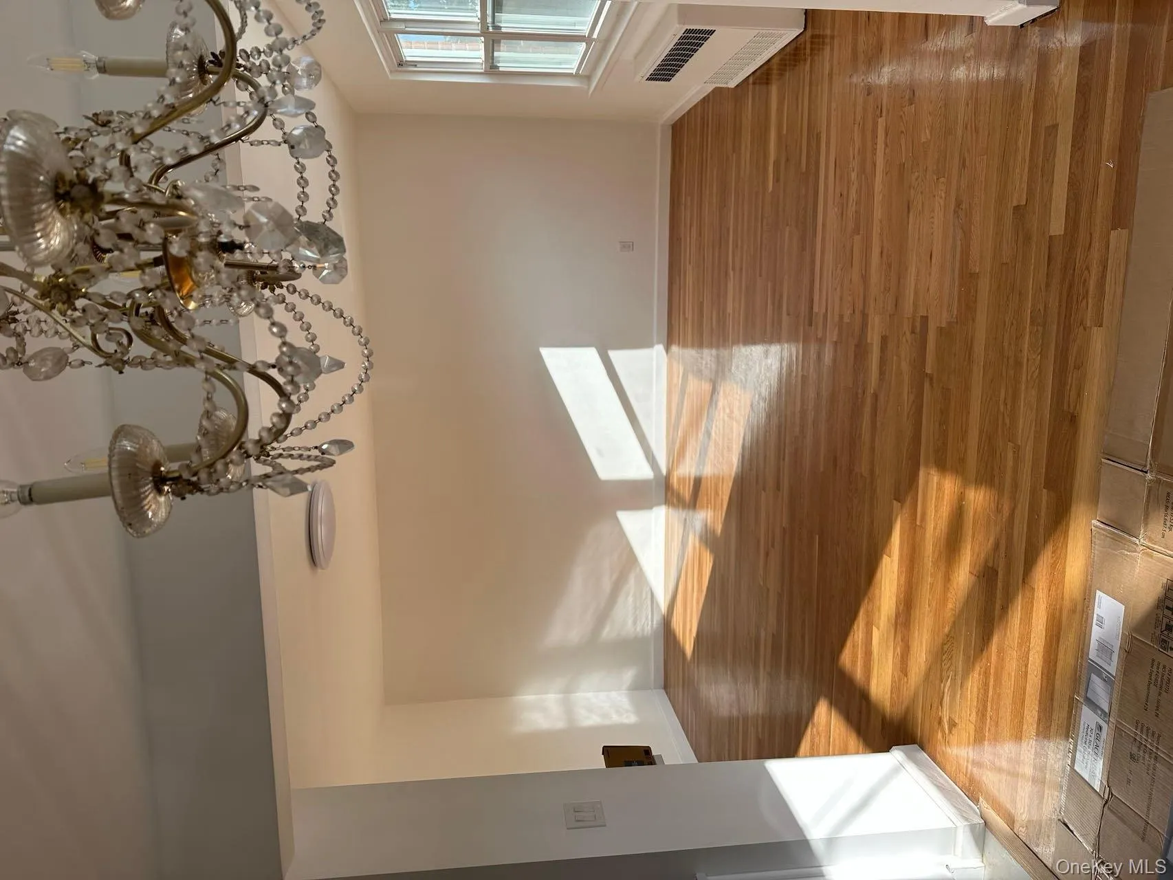 Unfurnished dining area with a chandelier, radiator heating unit, and light wood-type flooring Unfurnished dining area with a chandelier, radiator heating unit, and light wood-type flooring