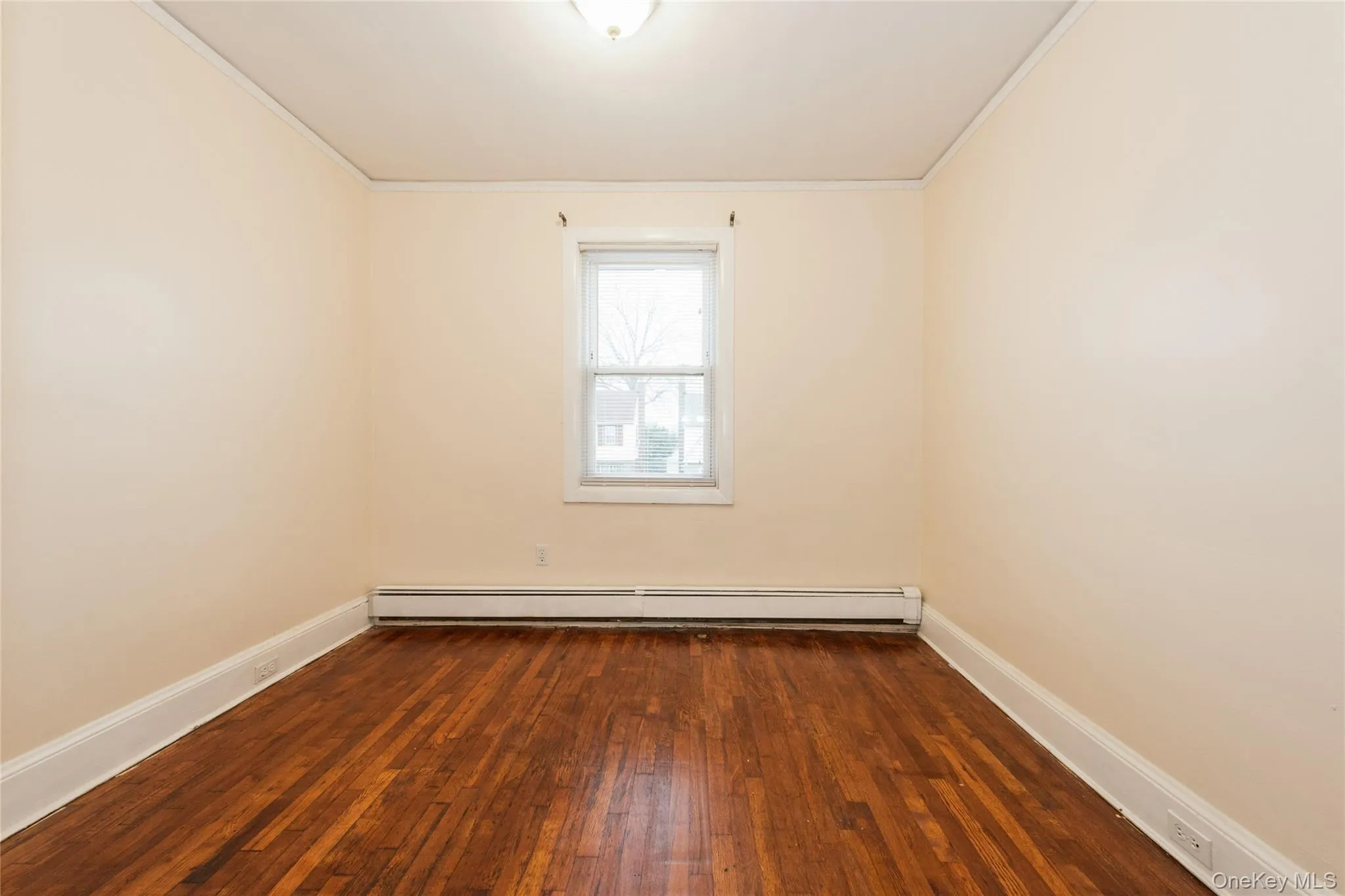 3rd Bedroom with hardwood flooring, crown molding, and a baseboard radiator. 3rd Bedroom with hardwood flooring, crown molding, and a baseboard radiator.
