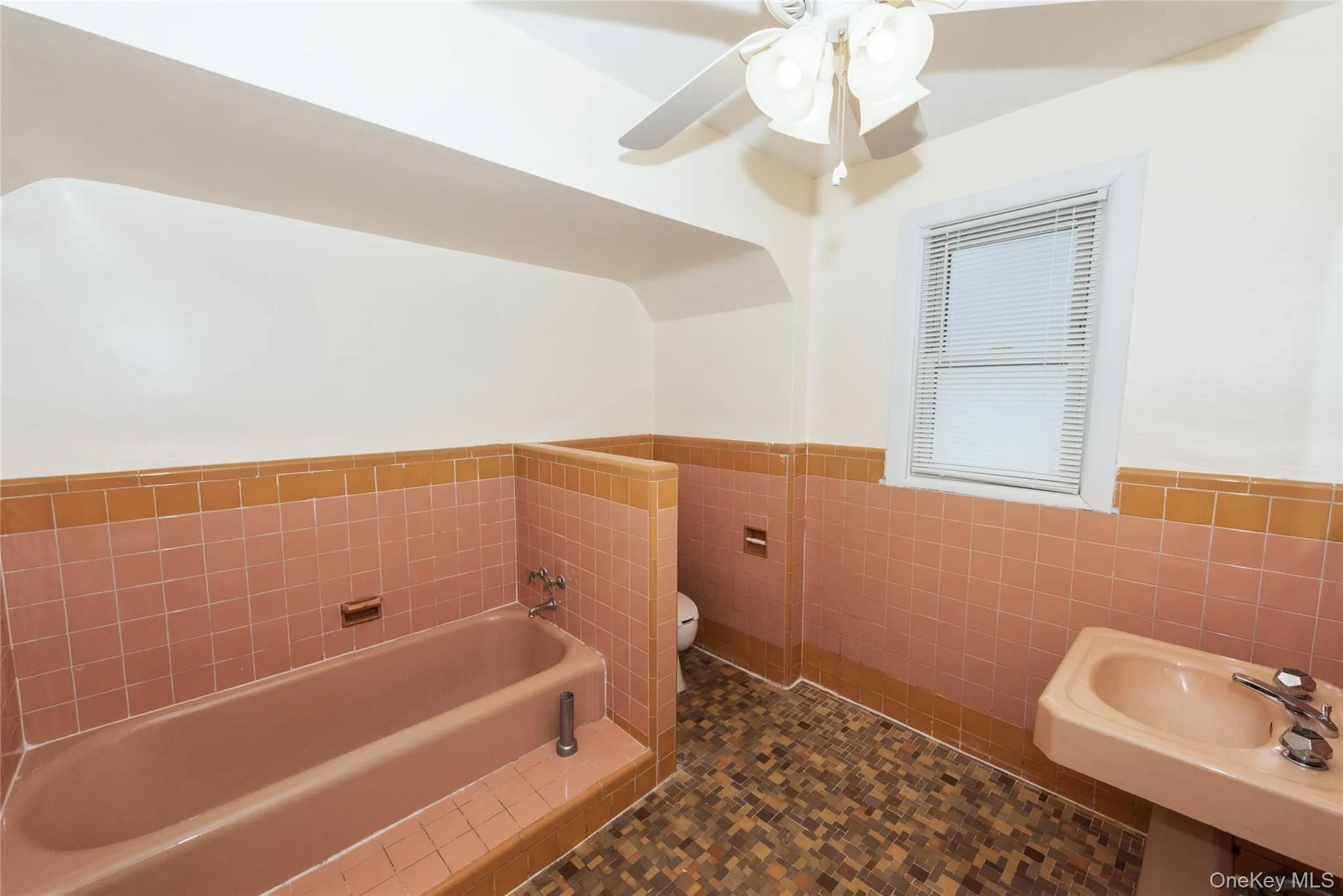 Upstairs Full-Bath with a wainscoted wall, tile walls, and bathtub and shower. Upstairs Full-Bath with a wainscoted wall, tile walls, and bathtub and shower.