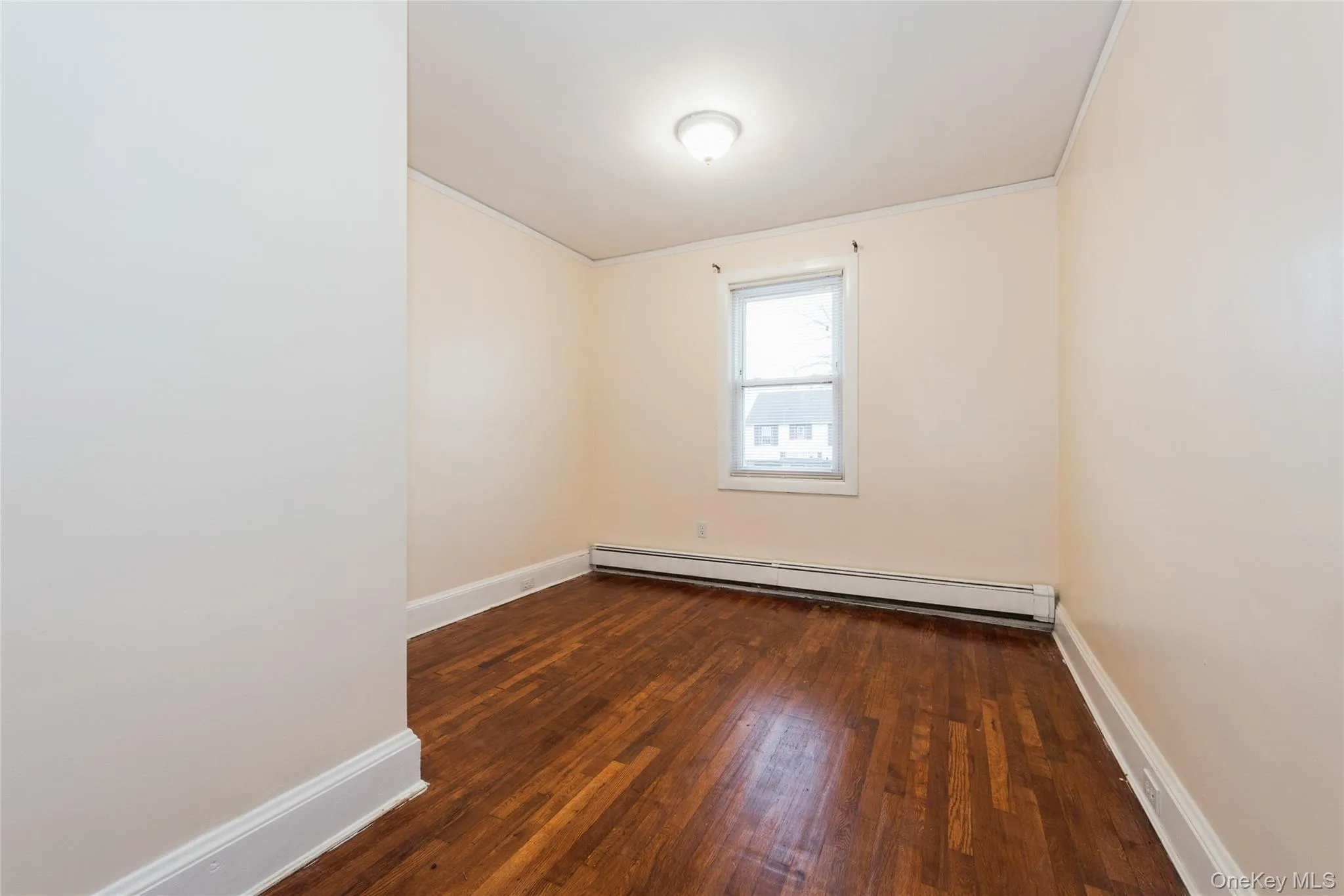 3rd Bedroom with hardwood flooring, crown molding, and a baseboard radiator. 3rd Bedroom with hardwood flooring, crown molding, and a baseboard radiator.