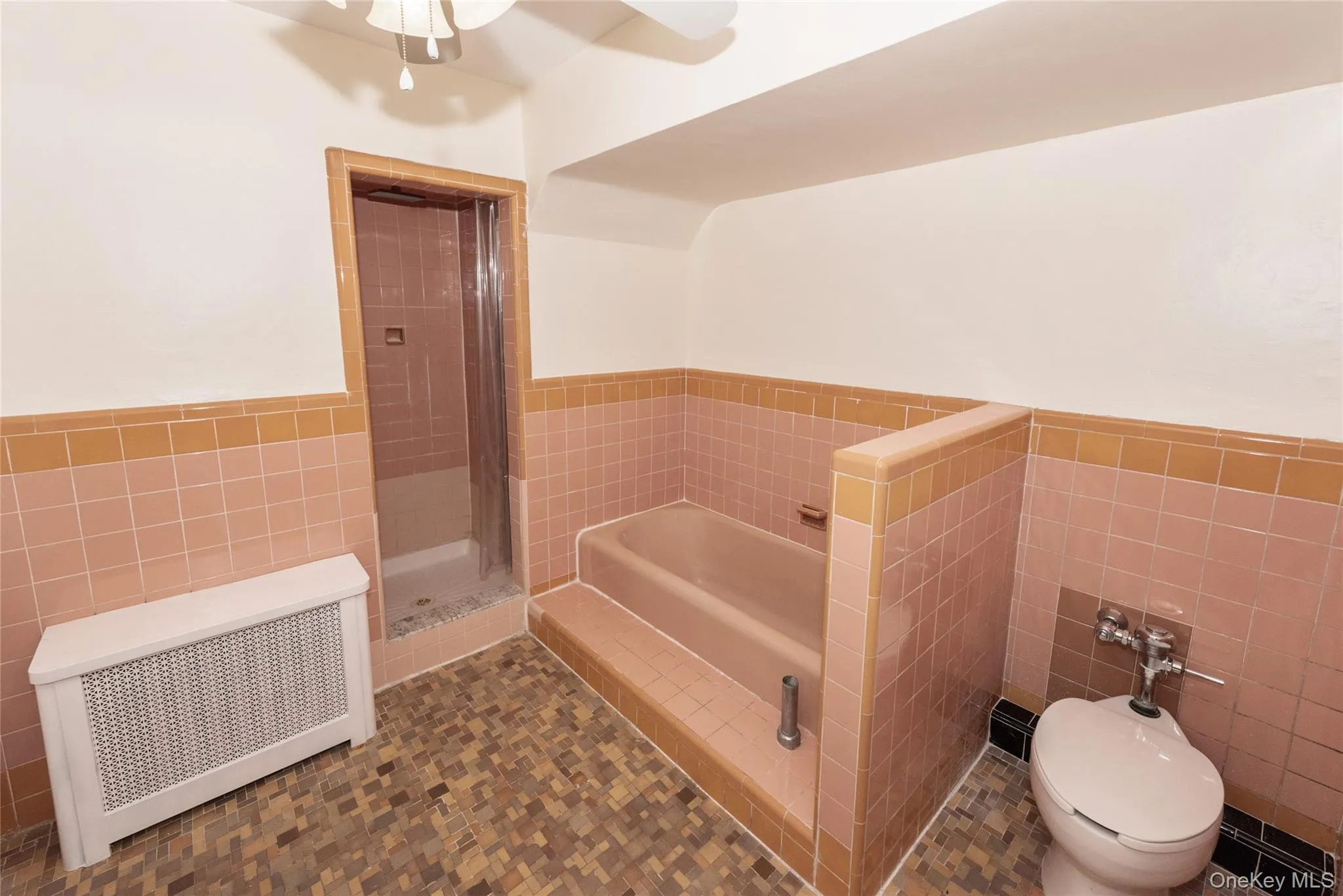 Upstairs Full-Bath with a wainscoted wall, tile walls, and bathtub and shower. Upstairs Full-Bath with a wainscoted wall, tile walls, and bathtub and shower.