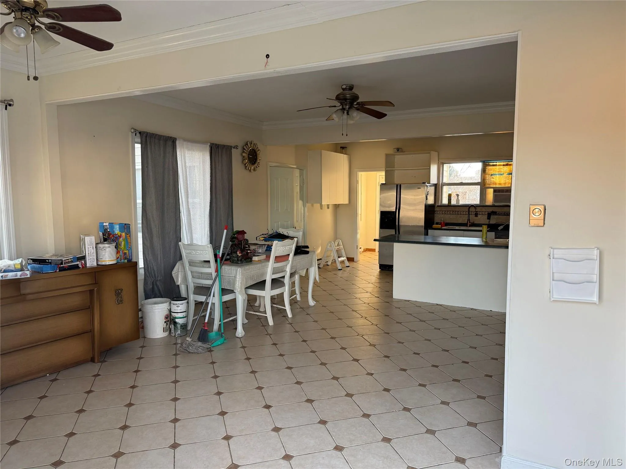 Dining room with ceiling fan, ornamental molding, healthy amount of natural light, and light flooring Dining room with ceiling fan, ornamental molding, healthy amount of natural light, and light flooring