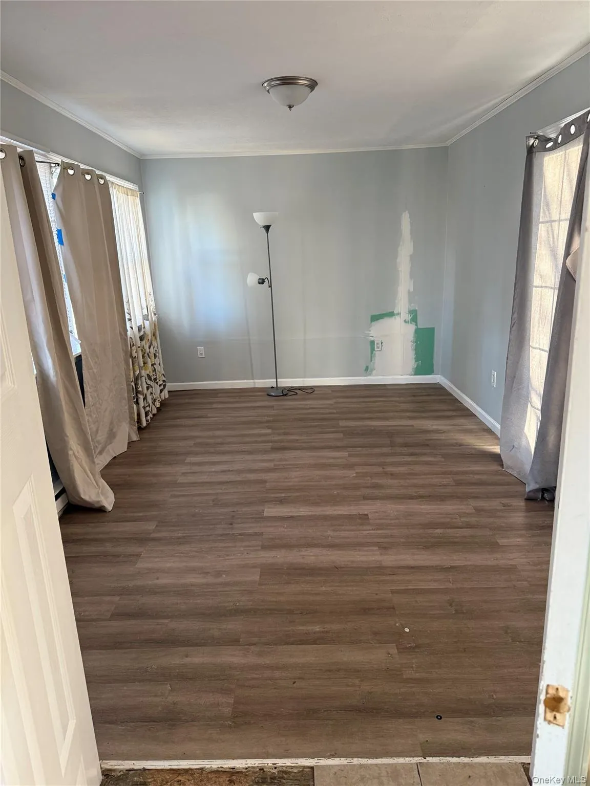 Unfurnished room with dark wood-style flooring and crown molding Unfurnished room with dark wood-style flooring and crown molding