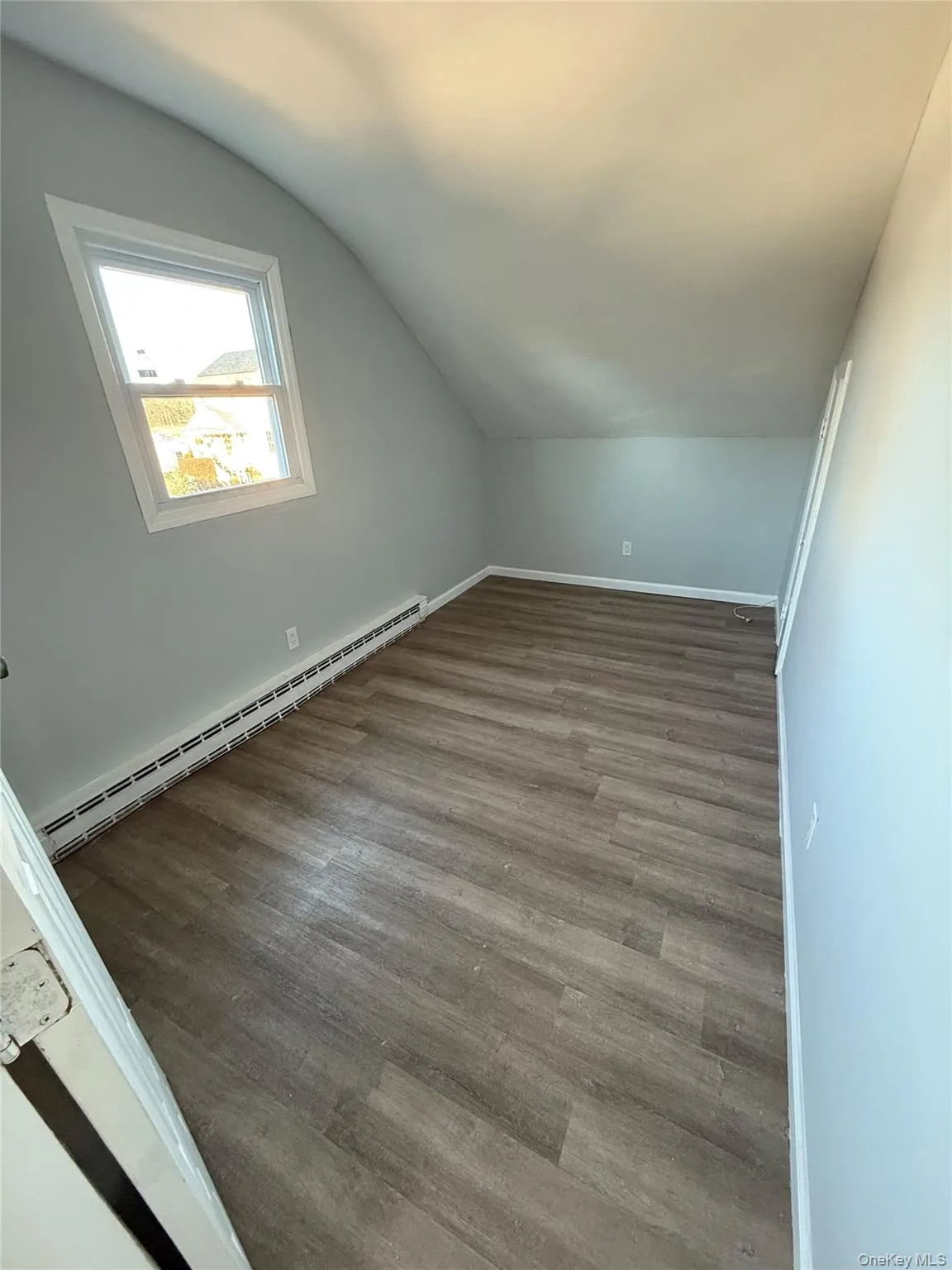 Bonus room with baseboard heating, wood finished floors, and lofted ceiling Bonus room with baseboard heating, wood finished floors, and lofted ceiling