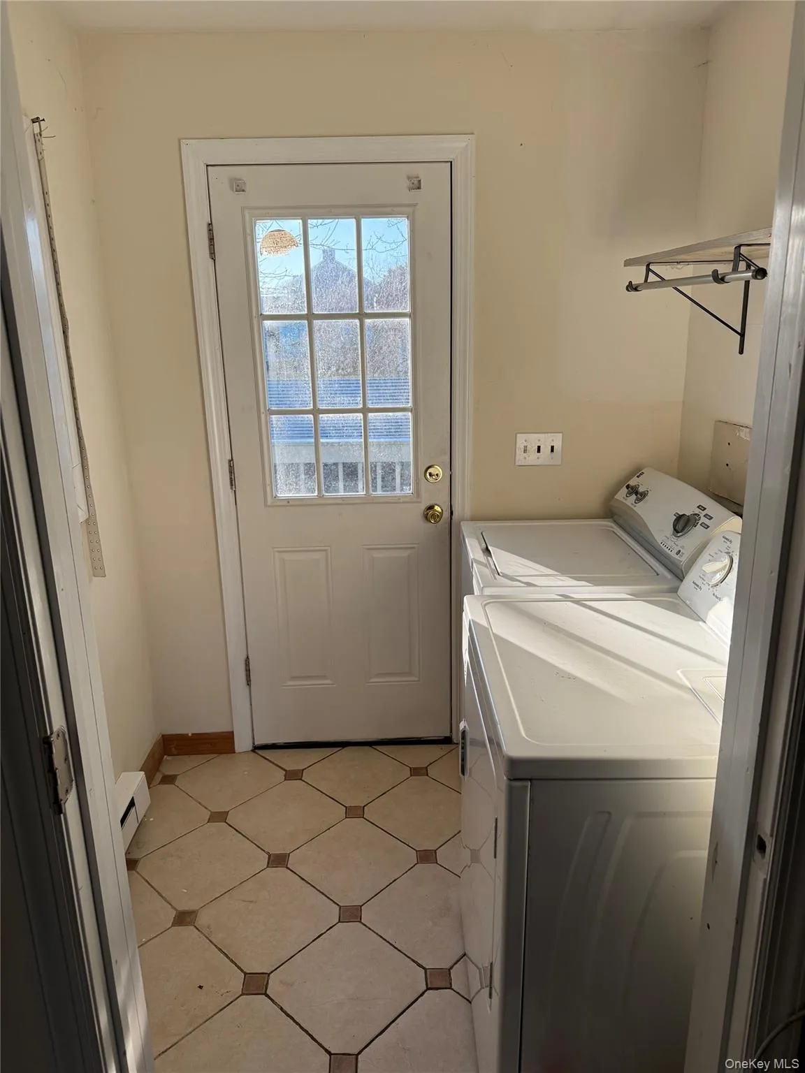 Laundry area featuring washer and dryer and baseboard heating Laundry area featuring washer and dryer and baseboard heating