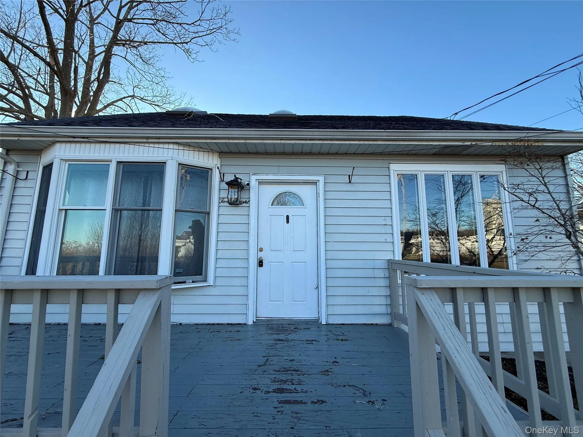 Entrance to property featuring a deck and roof with shingles Entrance to property featuring a deck and roof with shingles