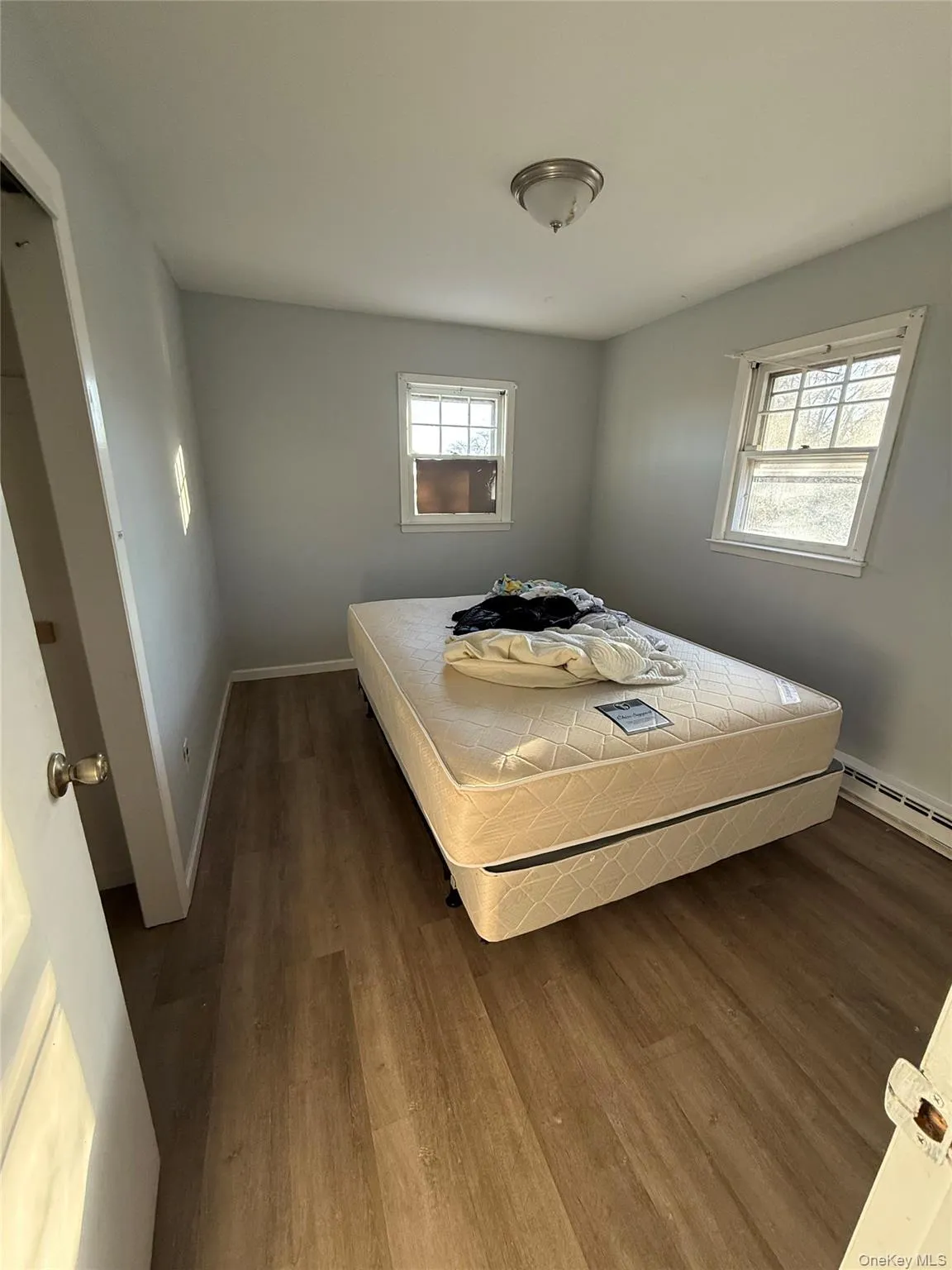 Bedroom with baseboard heating and wood finished floors Bedroom with baseboard heating and wood finished floors