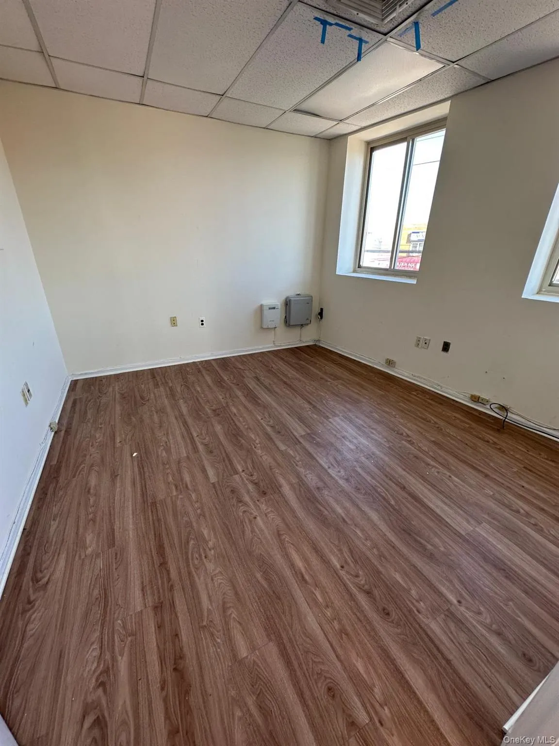 Unfurnished room with wood finished floors and a drop ceiling Unfurnished room with wood finished floors and a drop ceiling