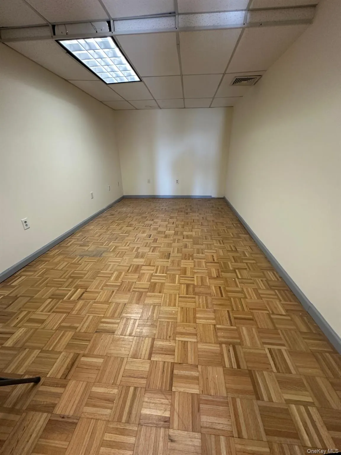 Empty room featuring baseboards and a paneled ceiling Empty room featuring baseboards and a paneled ceiling