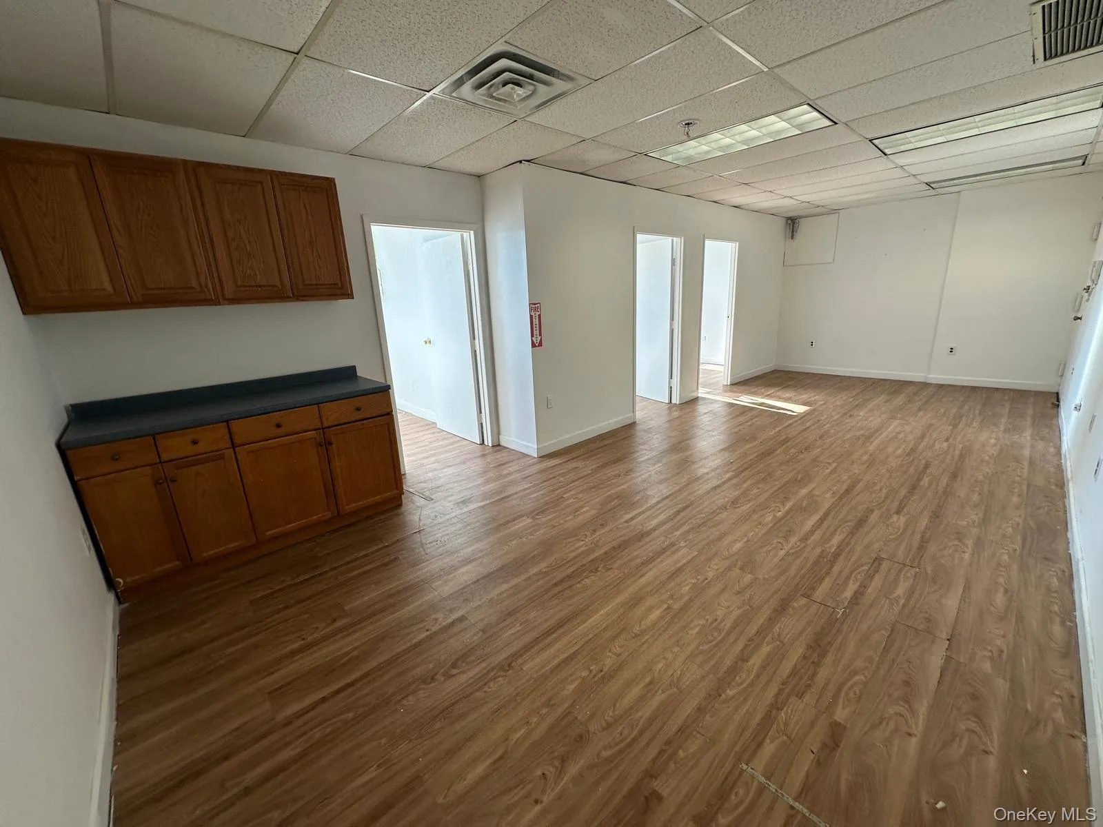 Unfurnished room with dark wood-style flooring and a paneled ceiling Unfurnished room with dark wood-style flooring and a paneled ceiling