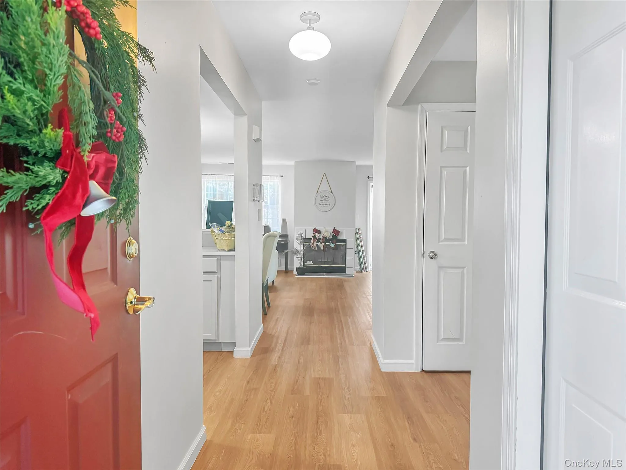 Corridor featuring light wood-style floors and baseboards Corridor featuring light wood-style floors and baseboards