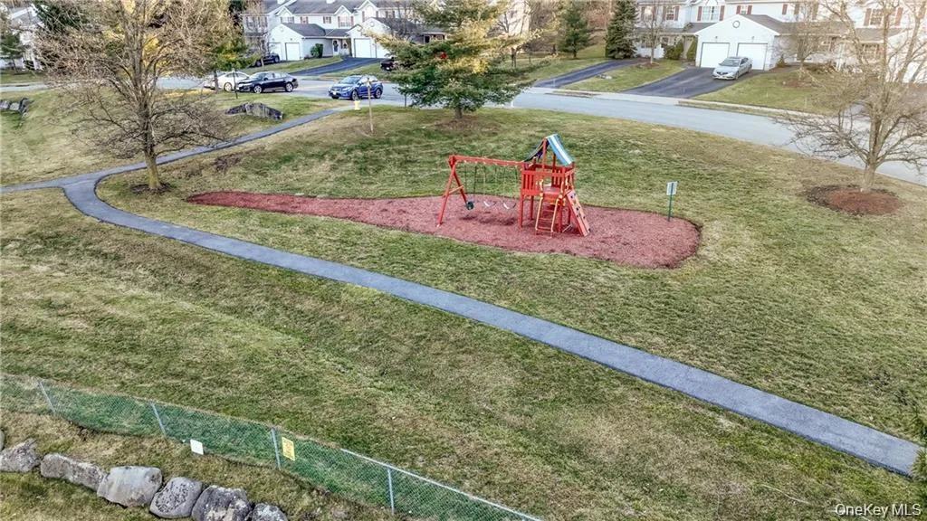 Community playground with a residential view and a yard Community playground with a residential view and a yard