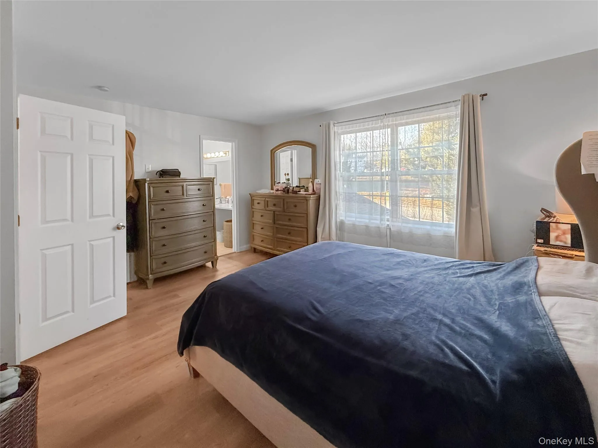 Bedroom with light wood finished floors and connected bathroom Bedroom with light wood finished floors and connected bathroom