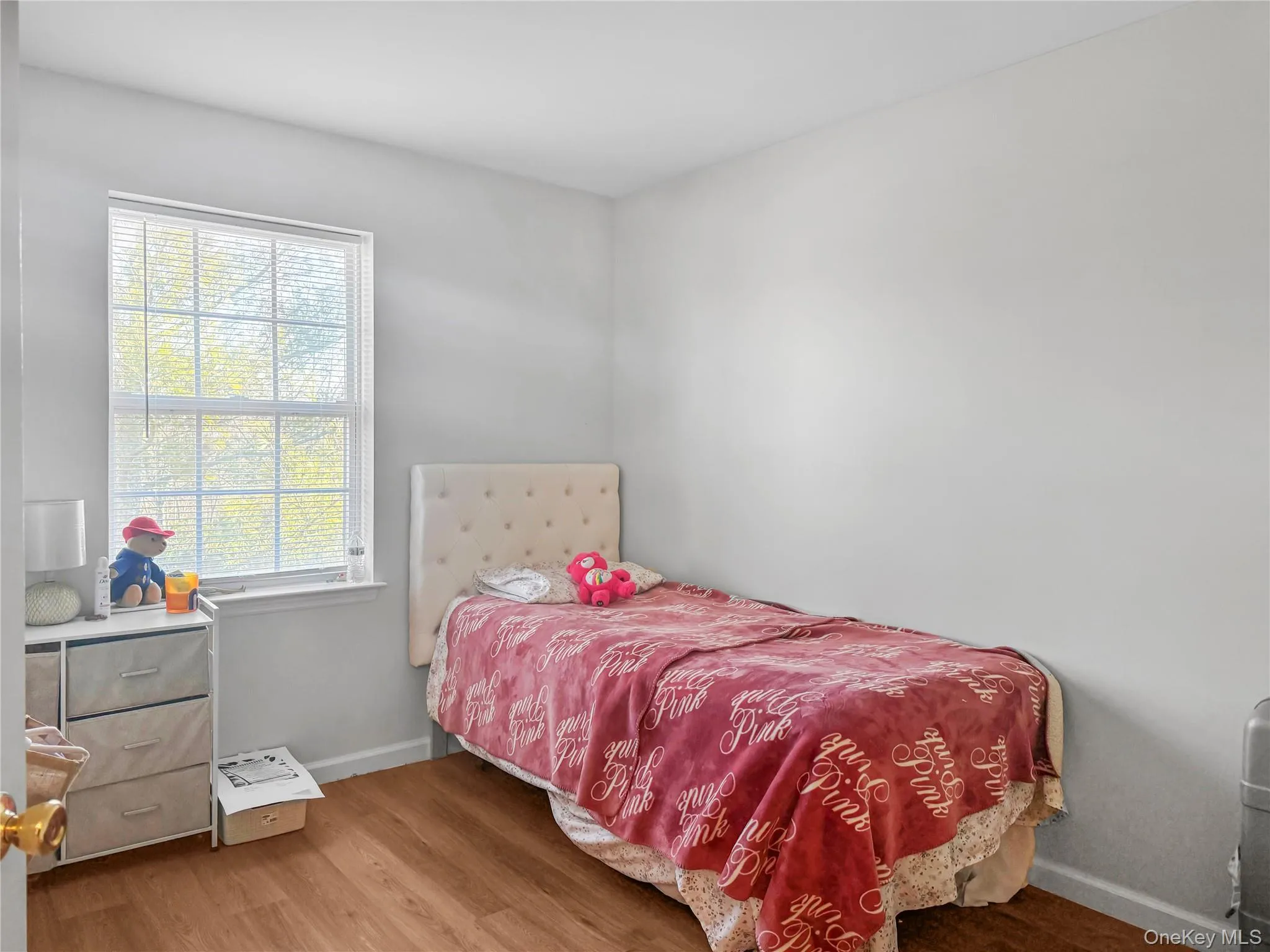Bedroom featuring wood finished floors and baseboards Bedroom featuring wood finished floors and baseboards