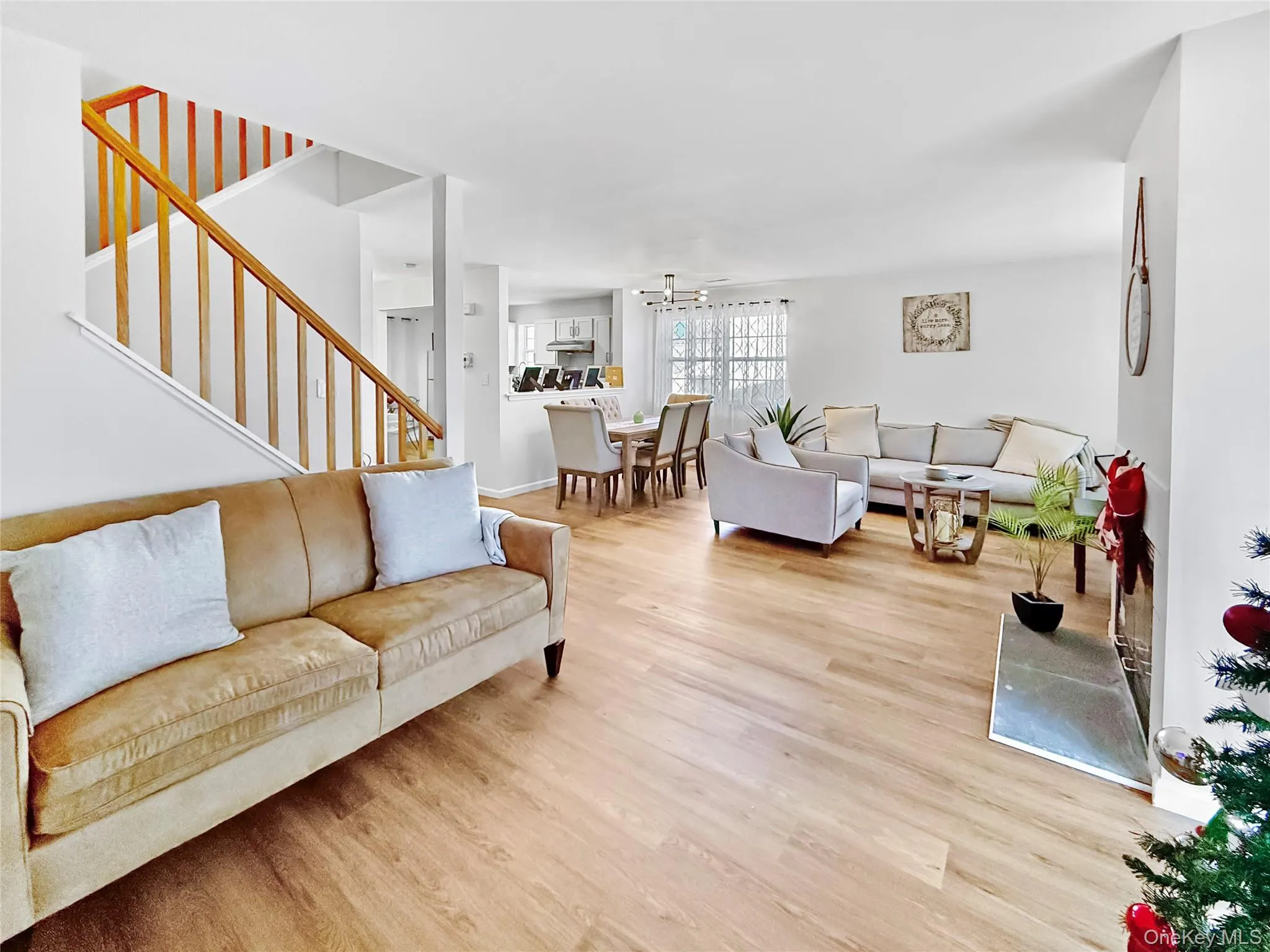 Living room featuring stairs, light wood-style floors, and a chandelier Living room featuring stairs, light wood-style floors, and a chandelier