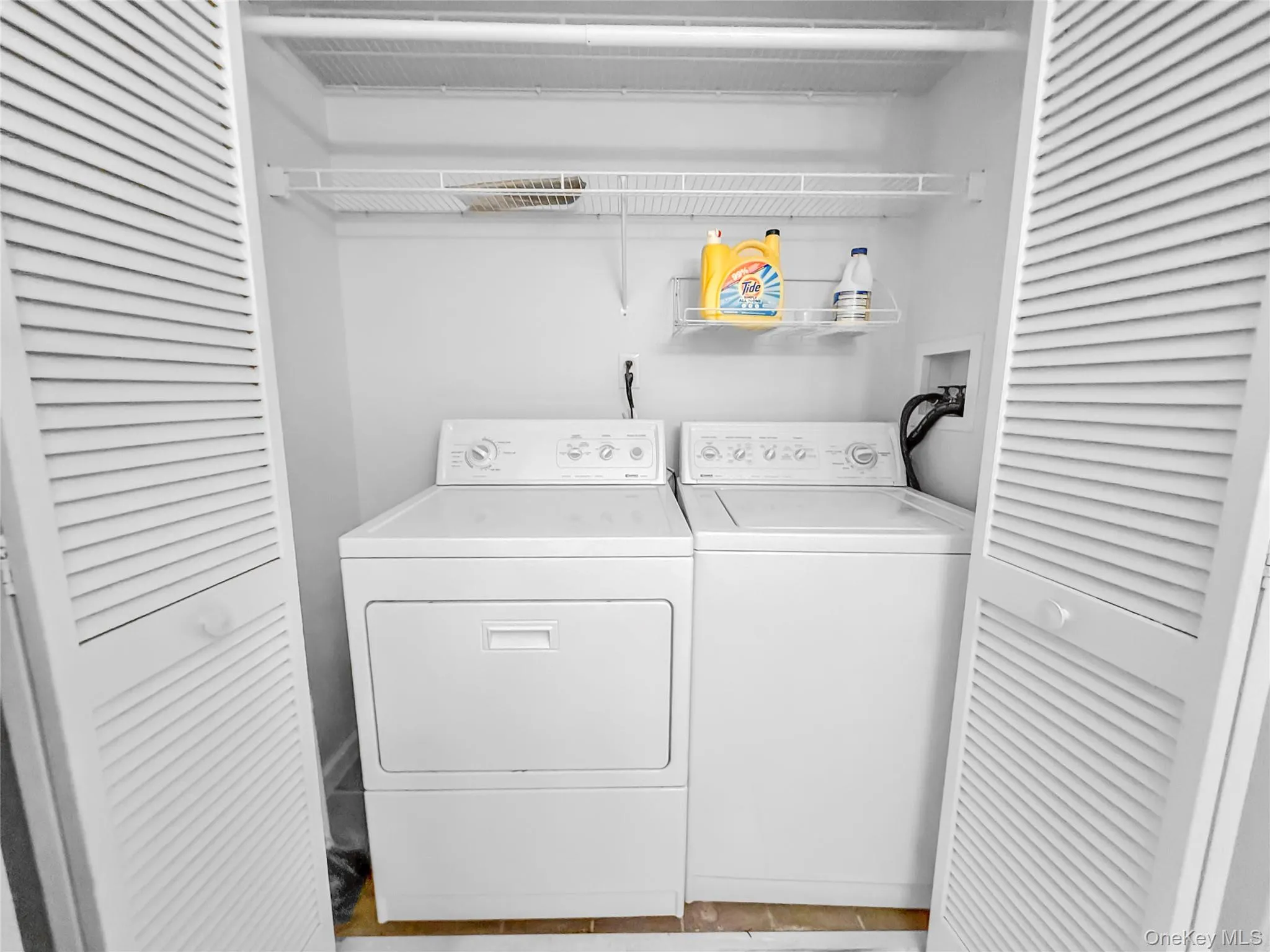 Laundry area with washer and dryer and light tile patterned floors Laundry area with washer and dryer and light tile patterned floors